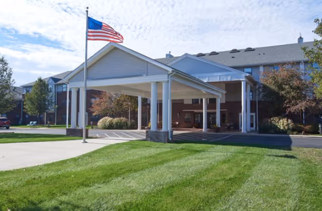 Exterior view of Canton Regency with a covered entrance, flagpole, and manicured lawn.