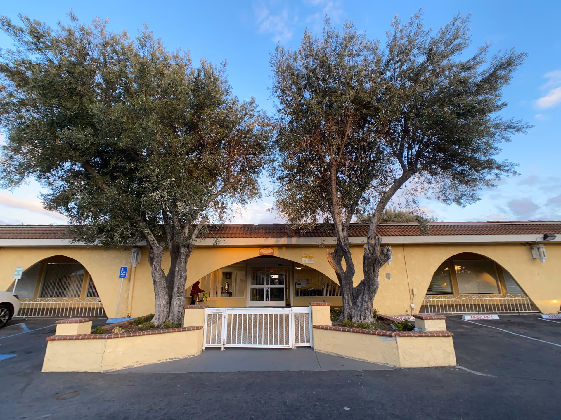 Front exterior of Woodruff Convalescent Center with arched windows and trees.