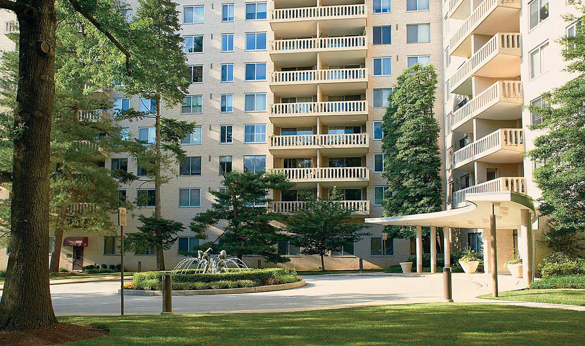 The Nova Home Care building front features balconies, trees, and a curved entrance canopy.
