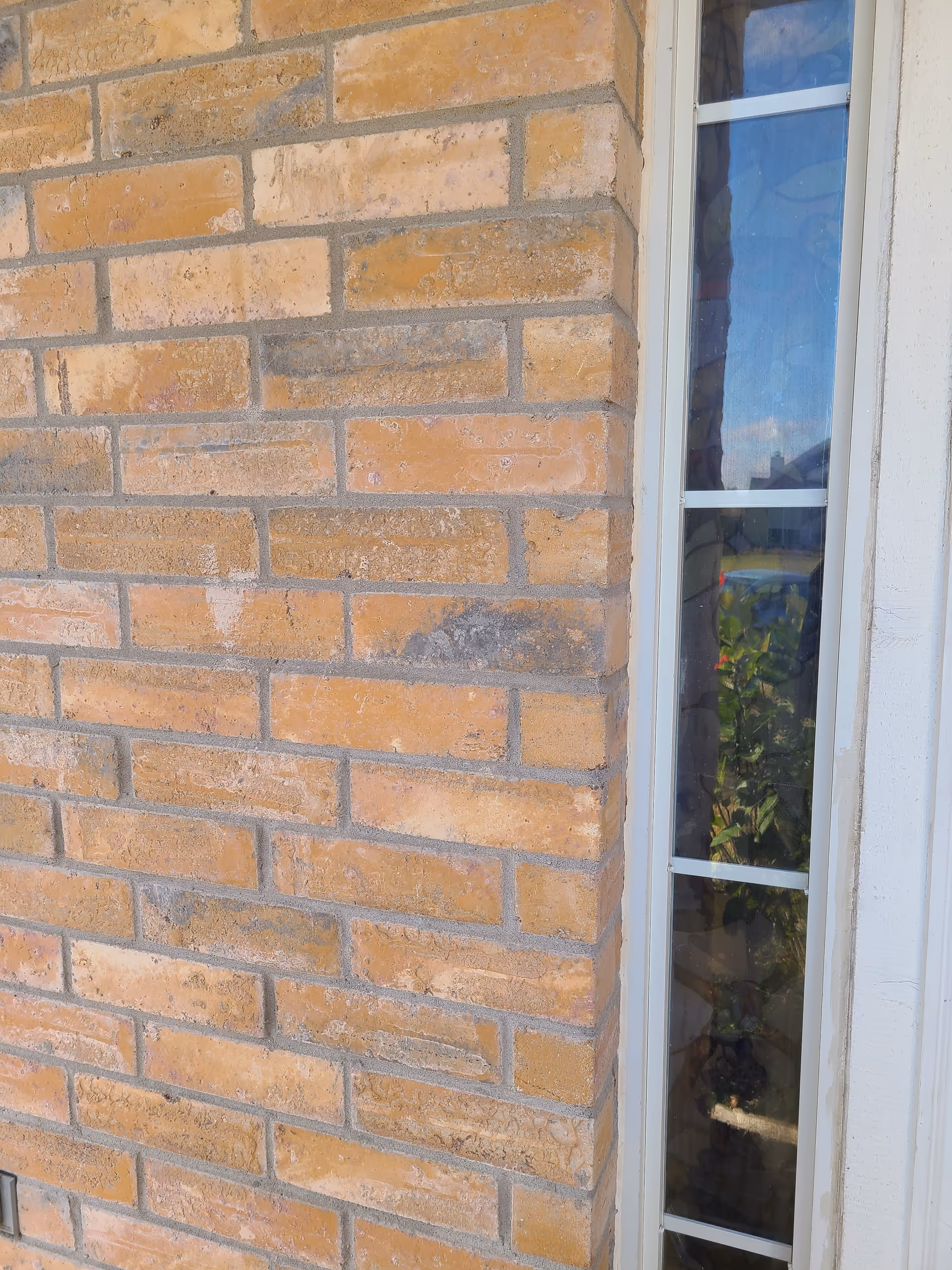 Brick exterior wall with a tall narrow window on the right side.