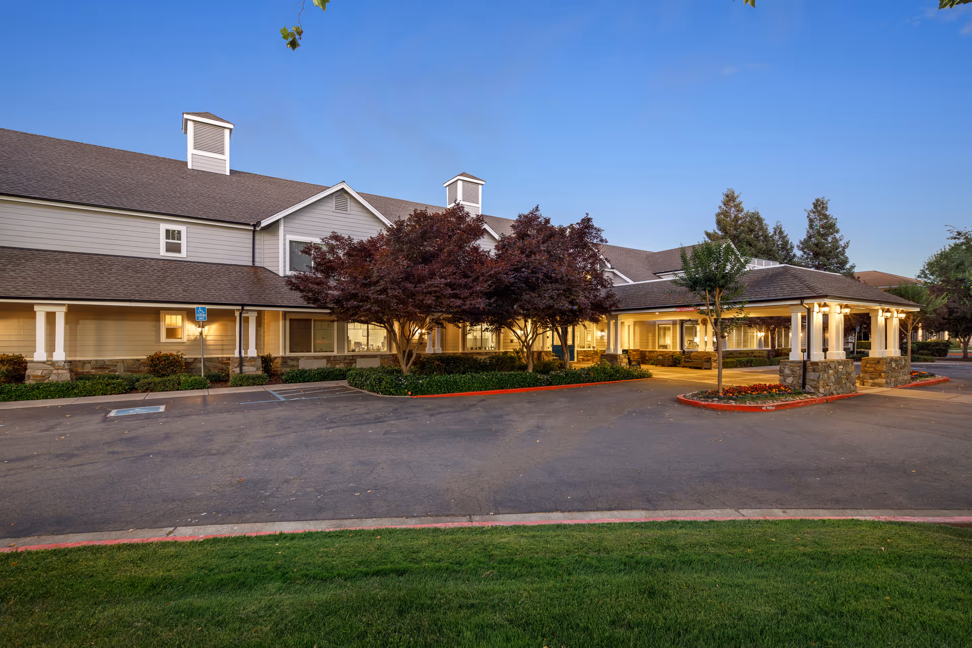 Exterior view of Oakmont of Brookside with a covered entrance, parking lot, and landscaping