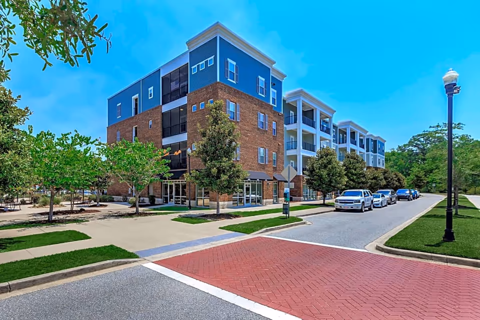 Exterior view of a modern senior living building with blue siding and brick facade.