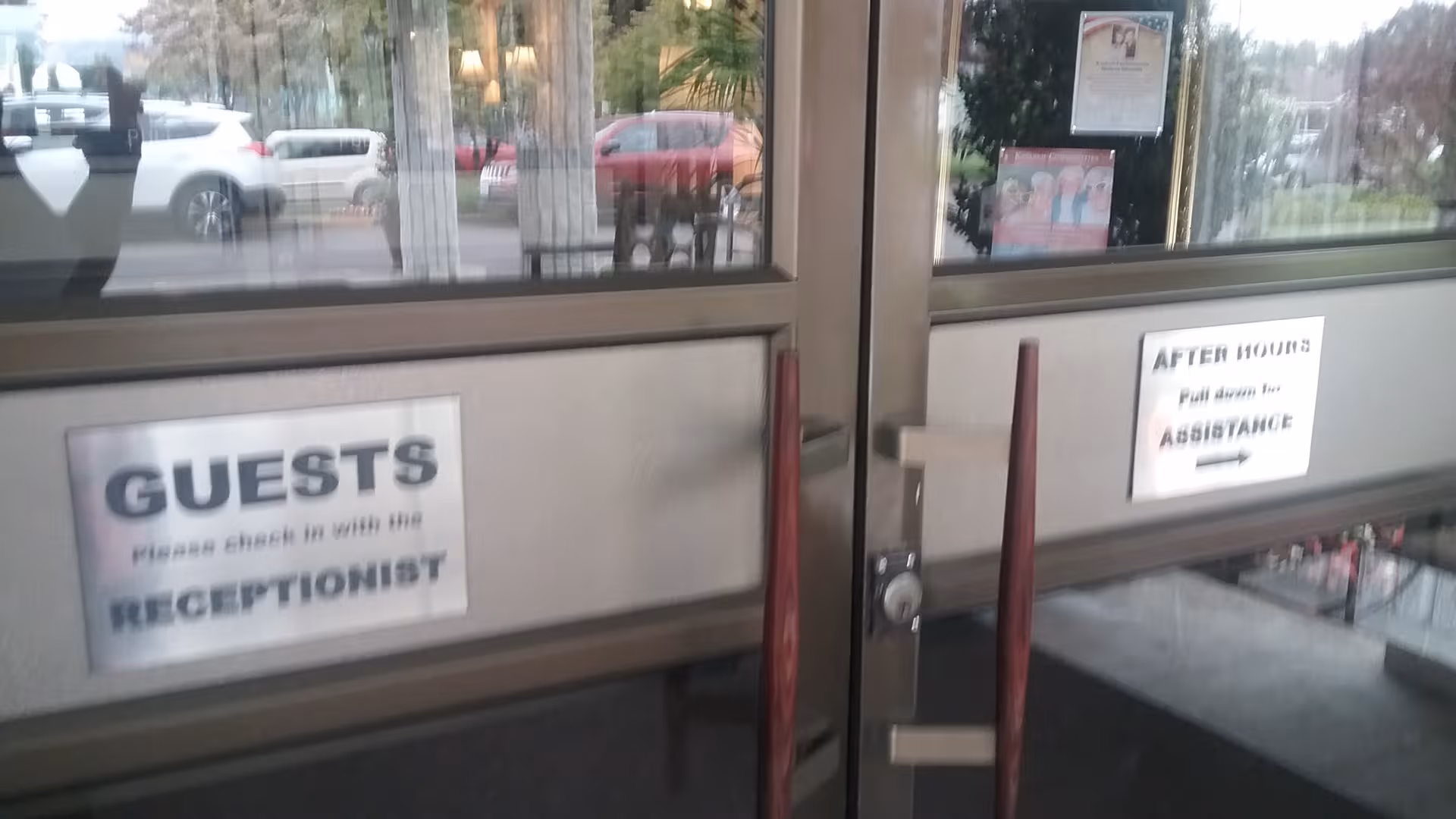 Entrance doors to Delaware Plaza Assisted Living Community with guest sign and after-hours assistance notice.