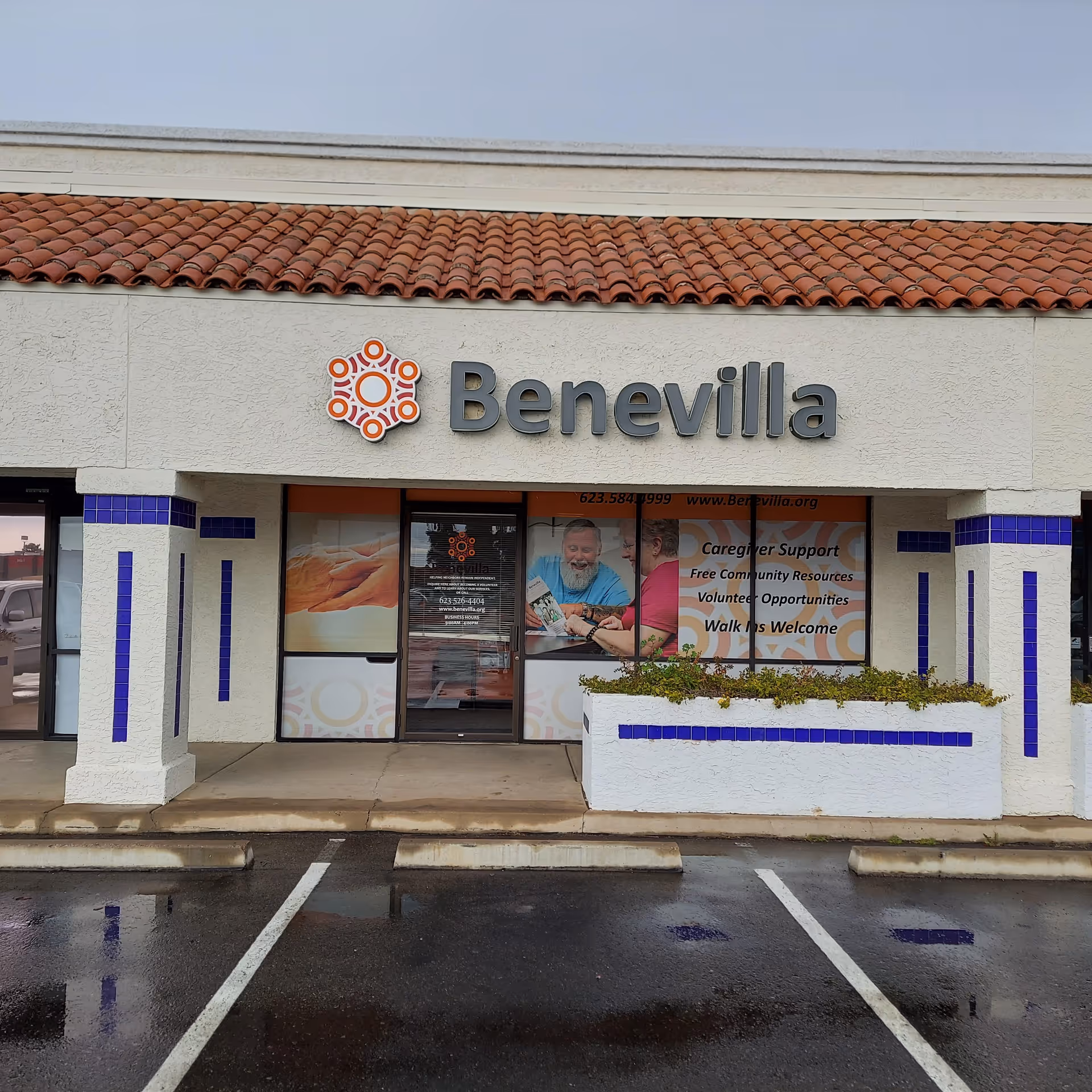 Front of Benevilla C.A.R.E.S. building with sign, tiles, and glass entry doors.