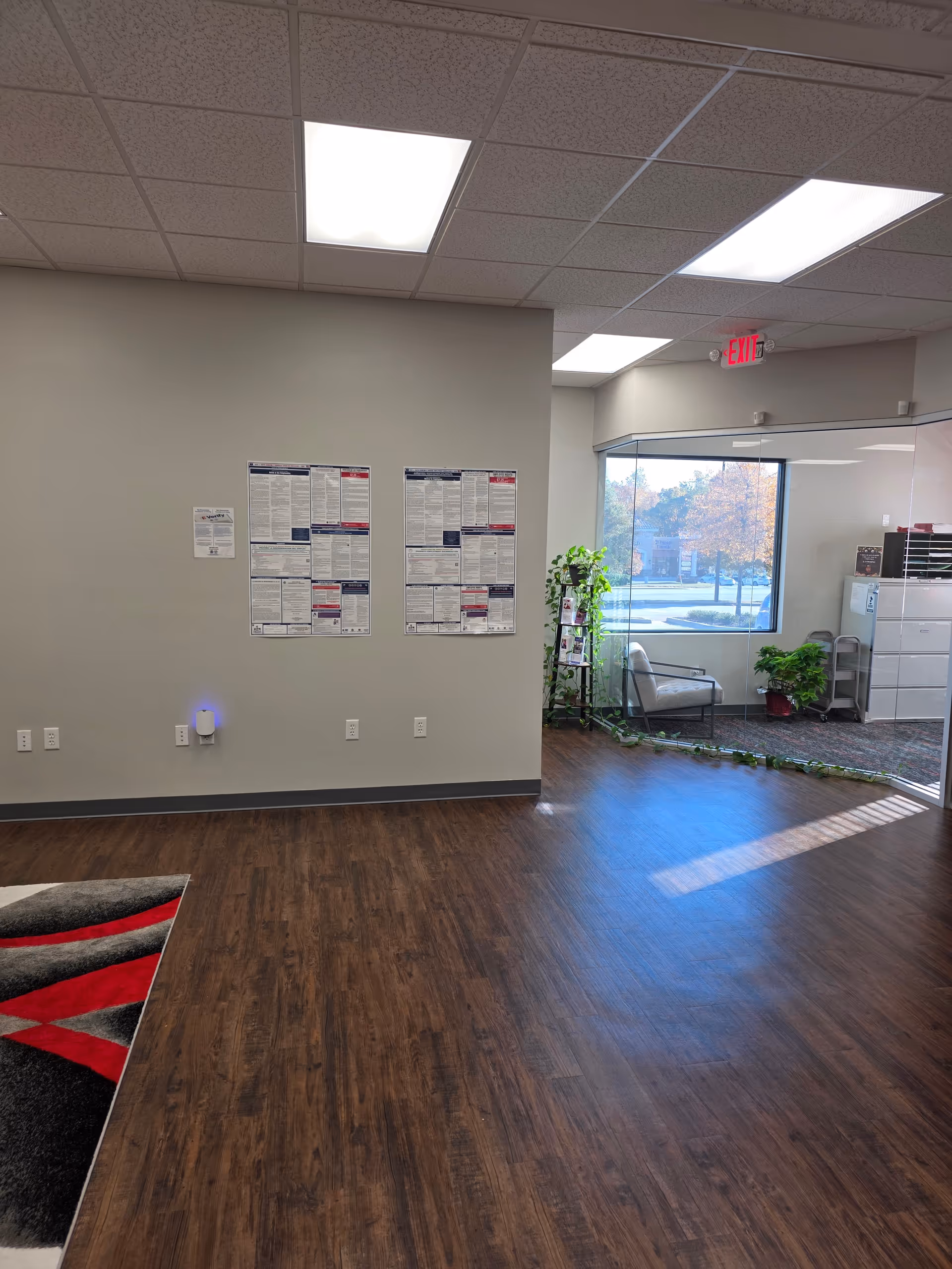 Interior lobby area of a senior facility with posters, glass doors, and plants