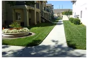 Exterior view of Abbey Road Villa showing a walkway and grassy courtyard.