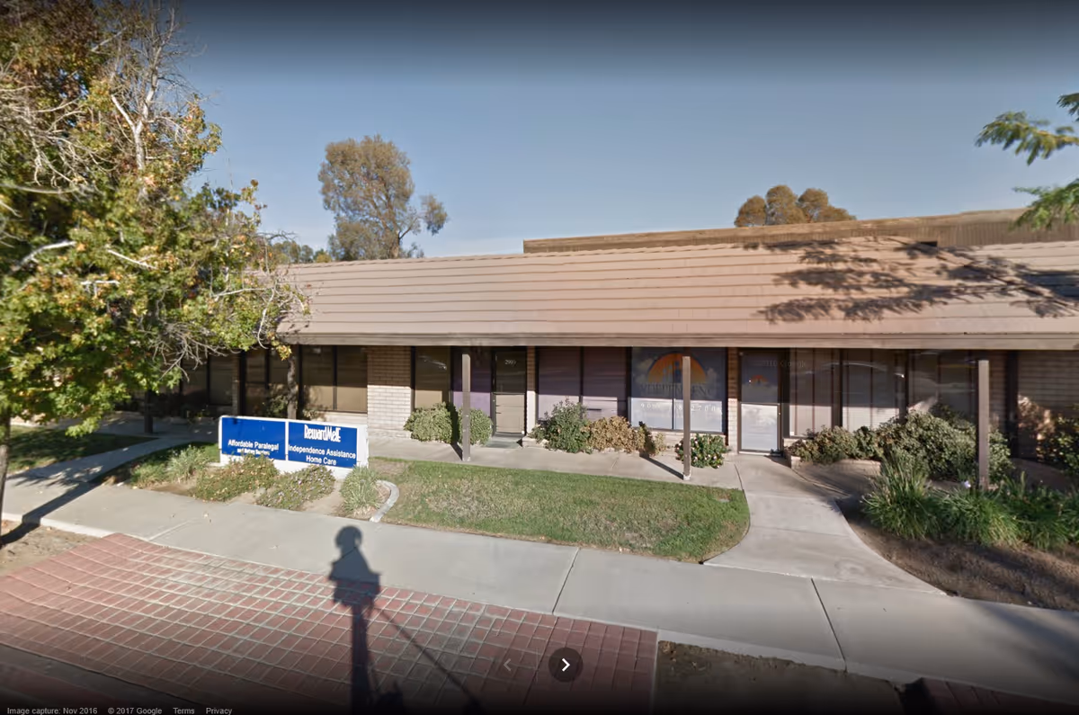 Single-story senior living facility exterior with brown roof and prominent entrance.