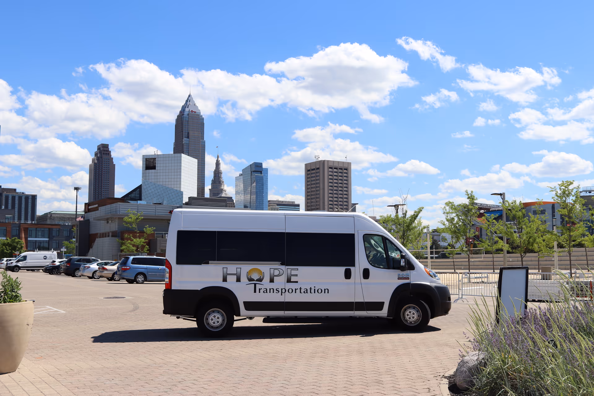 White Hope Transportation van parked in a lot with city skyline.