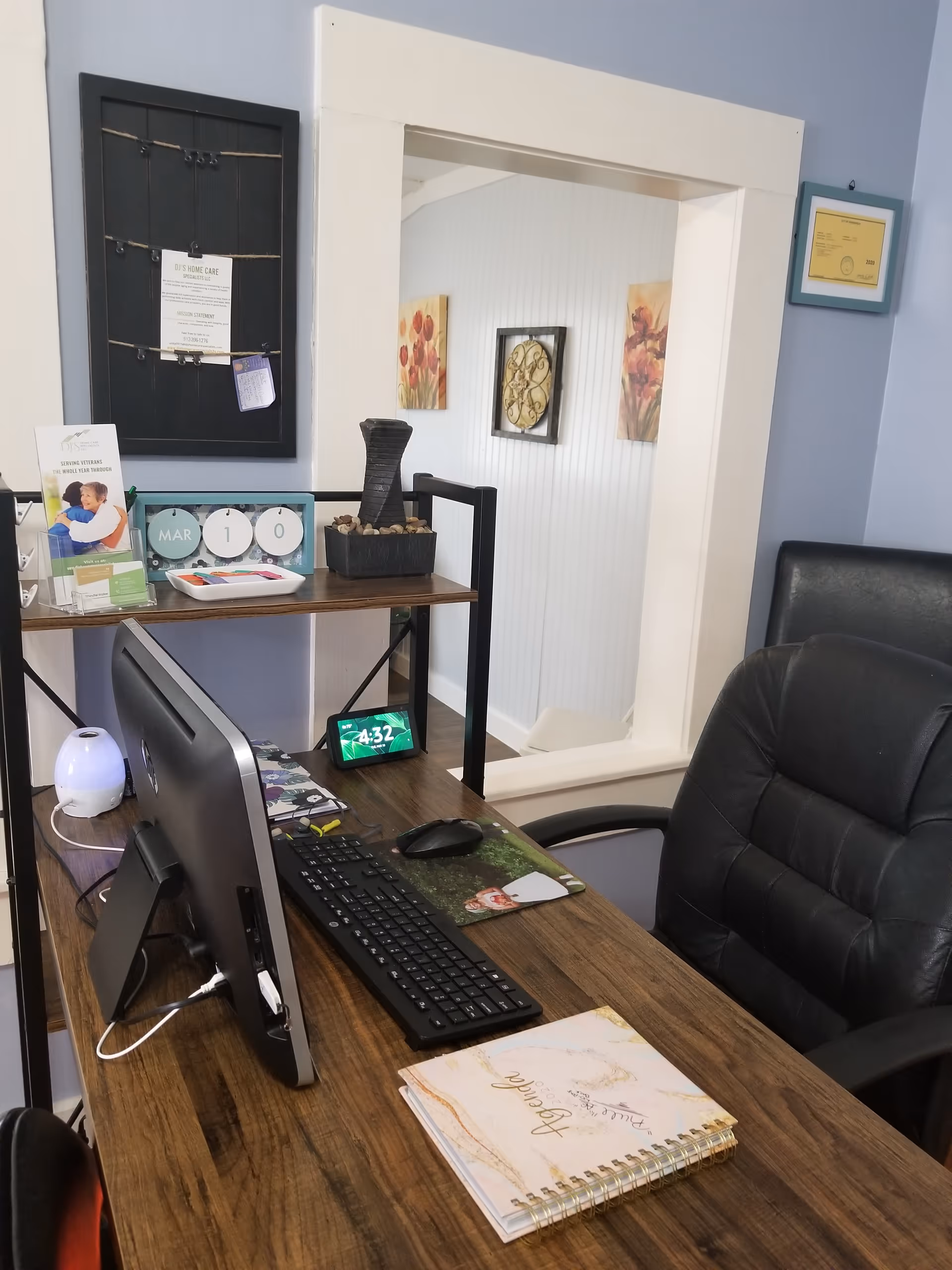Office desk with computer and notebook inside a senior care facility.