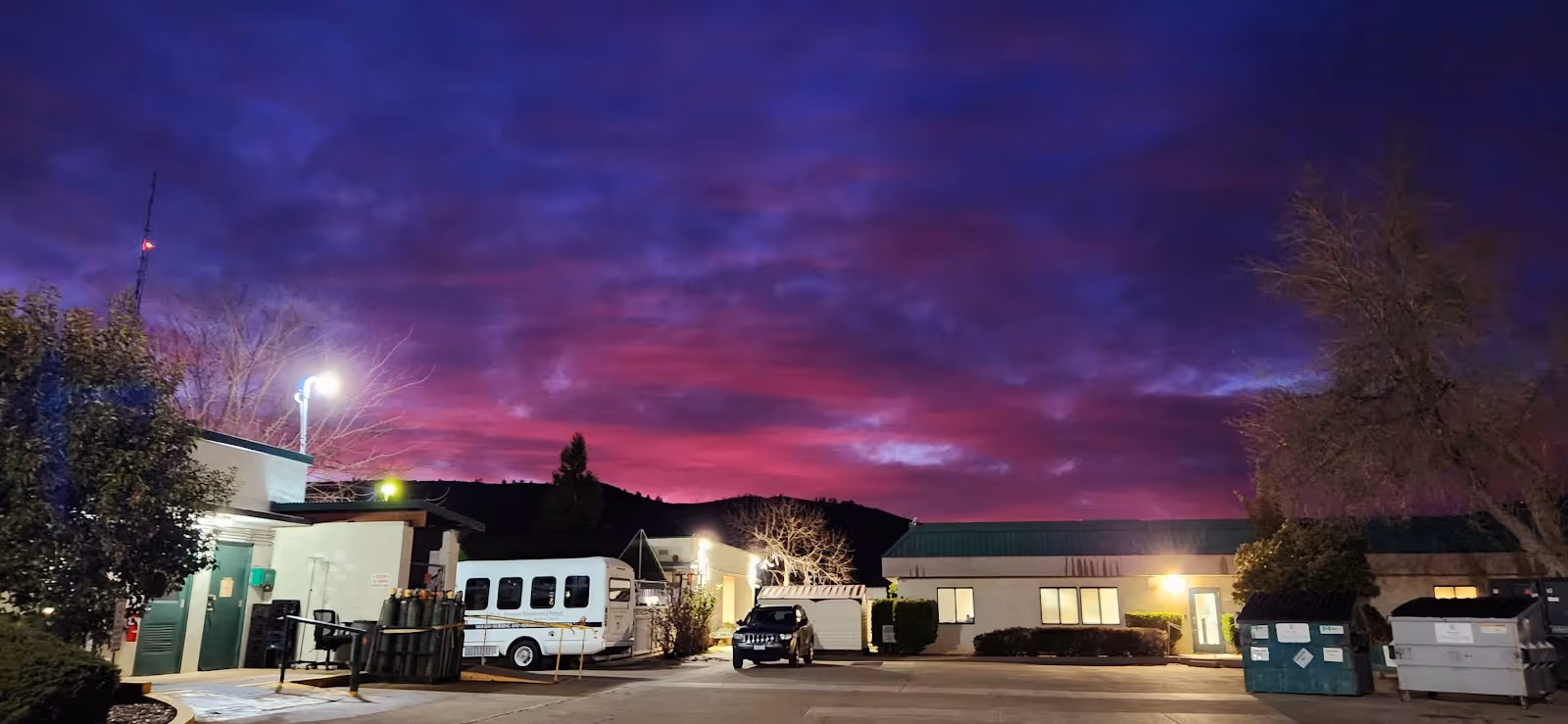 Exterior view of John C. Fremont Healthcare District facility at dusk with bus in parking lot.
