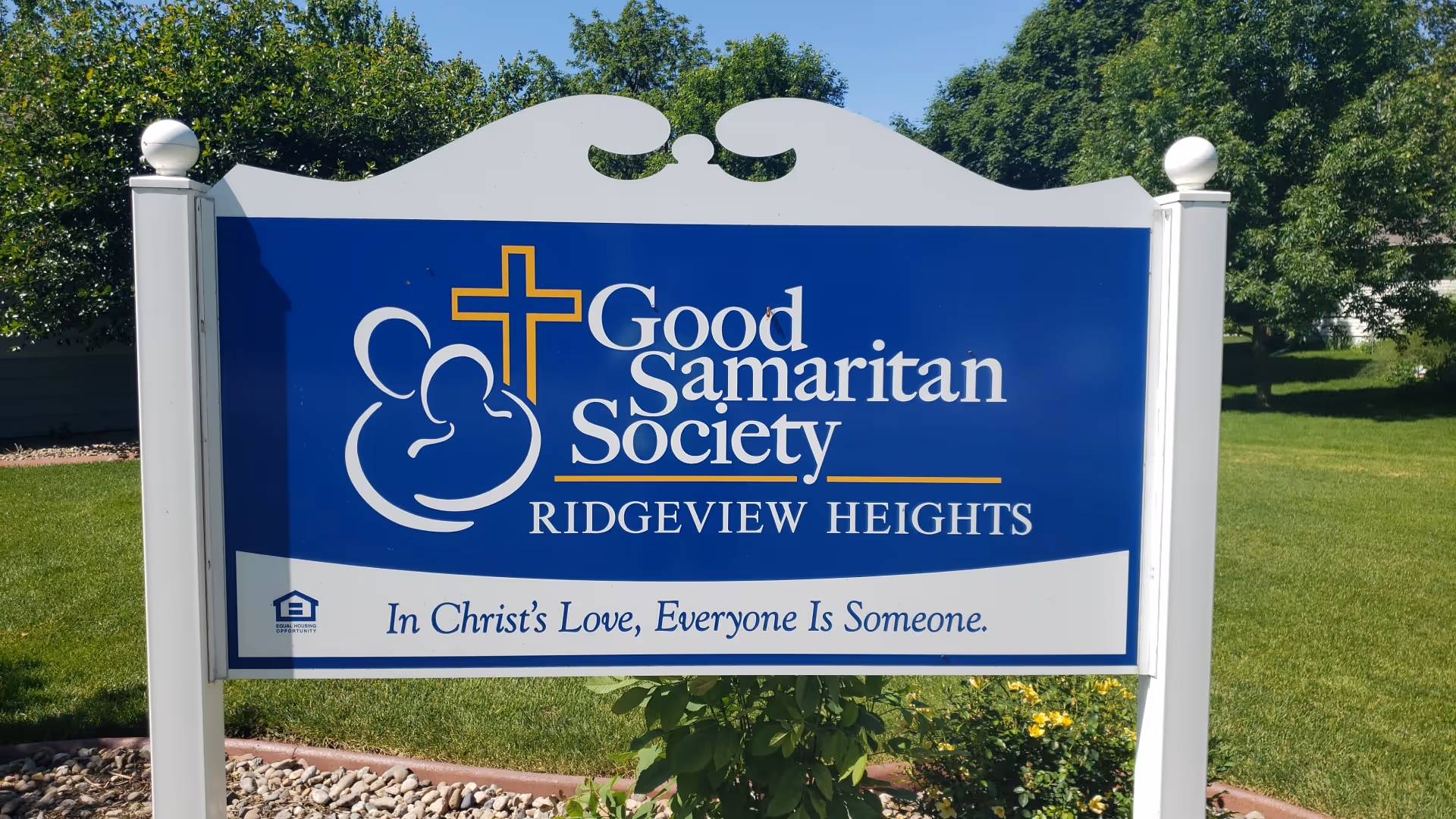 Outdoor blue sign for Good Samaritan Society Ridgeview Heights on a green lawn.