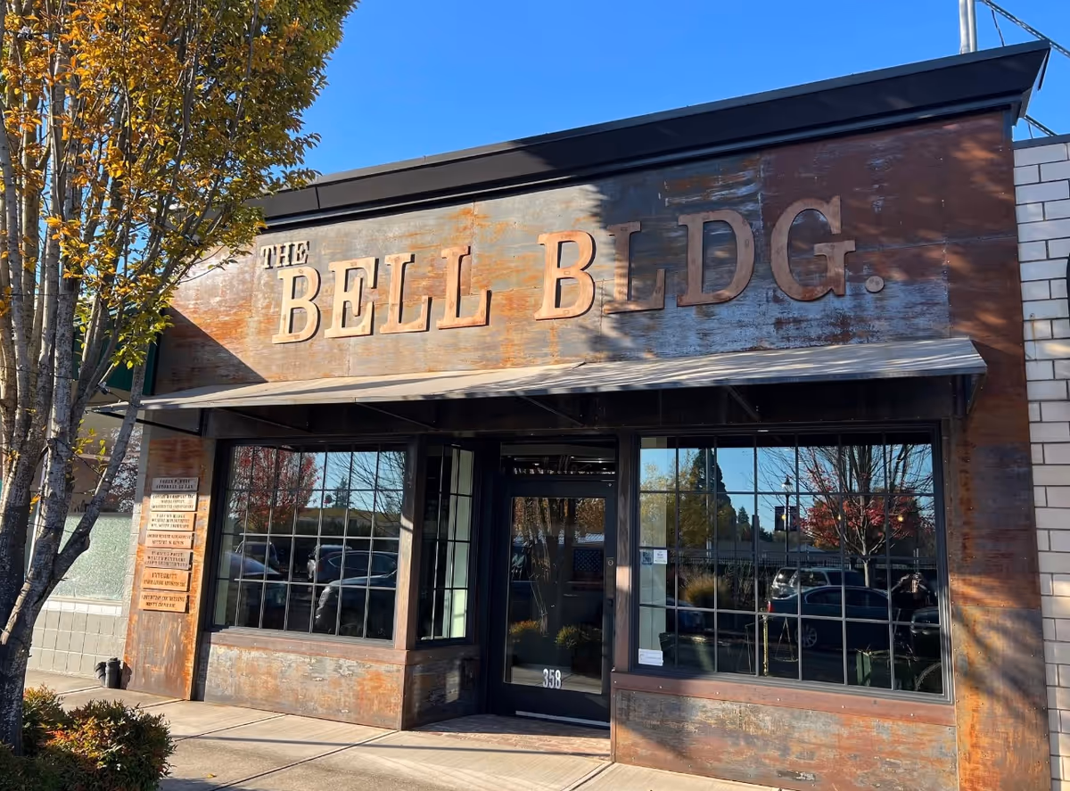 Rustic storefront with large The Bell Bldg sign on exterior building facade.
