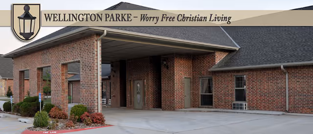 Brick senior living facility entrance with covered drop-off and manicured landscaping.