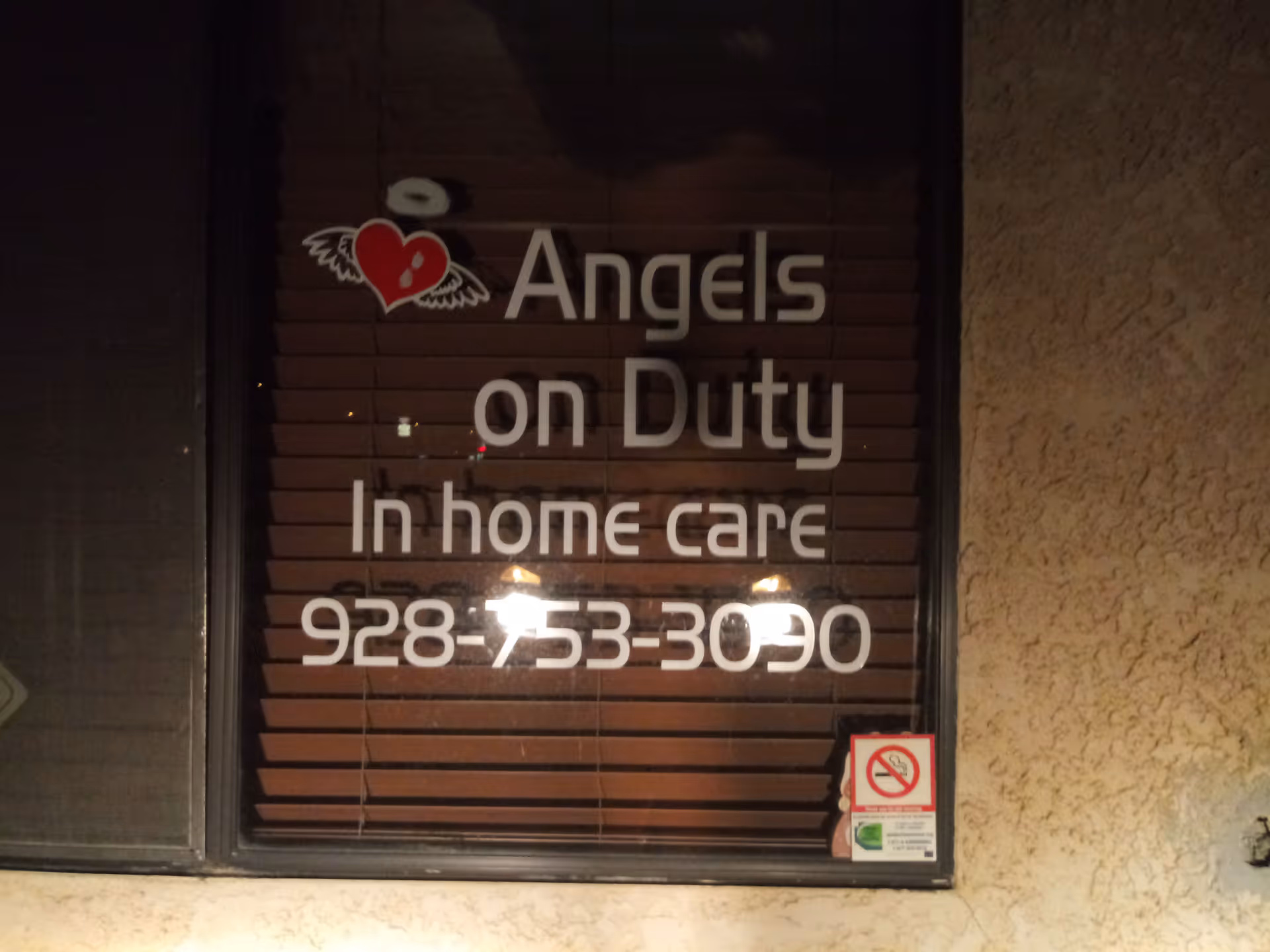 Storefront window displays Angels On Duty In Home Care with a heart logo and phone number.