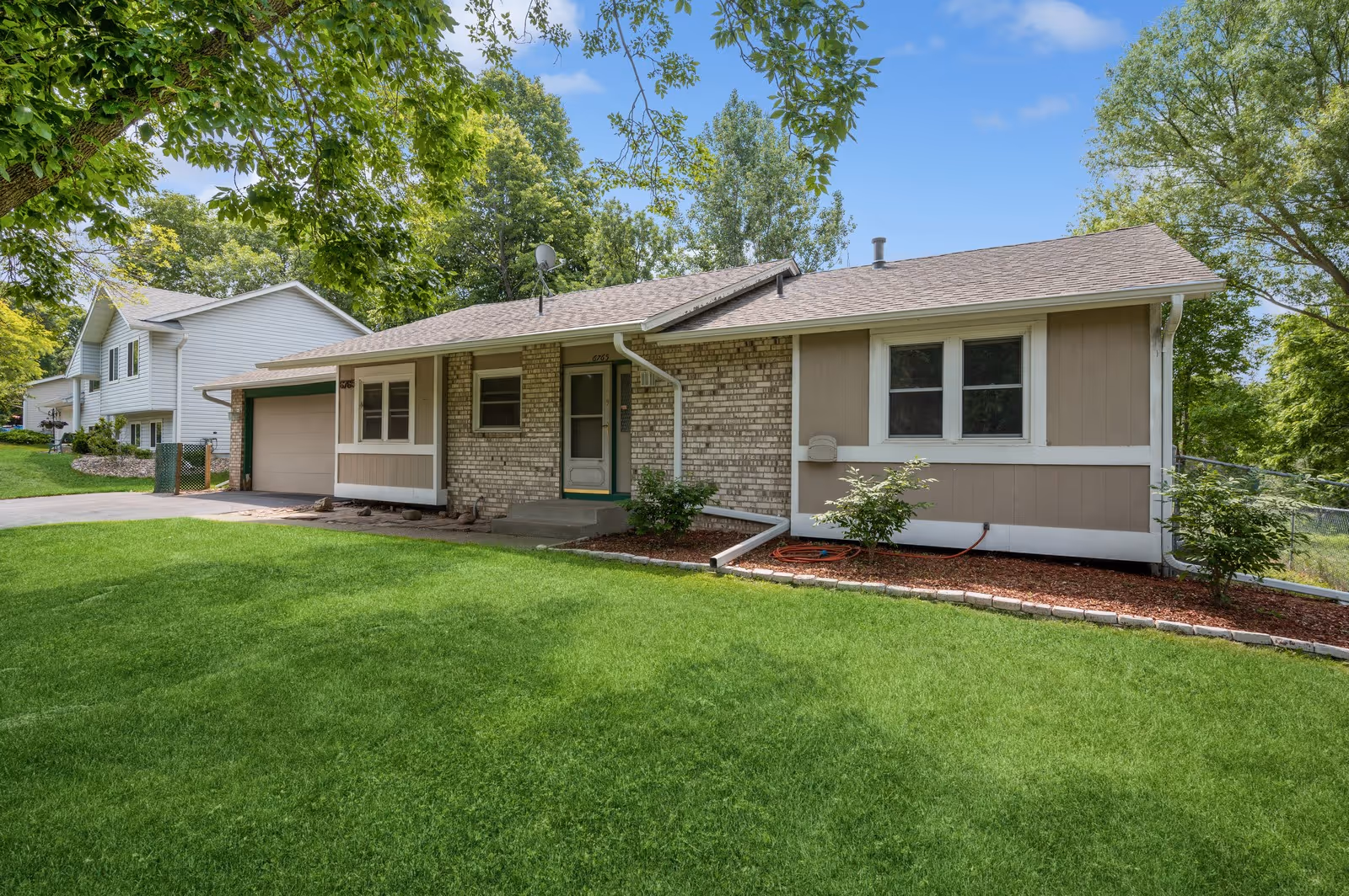 Single-story Blossom Hill LLC facility exterior with brick and beige siding, green lawn, trees.