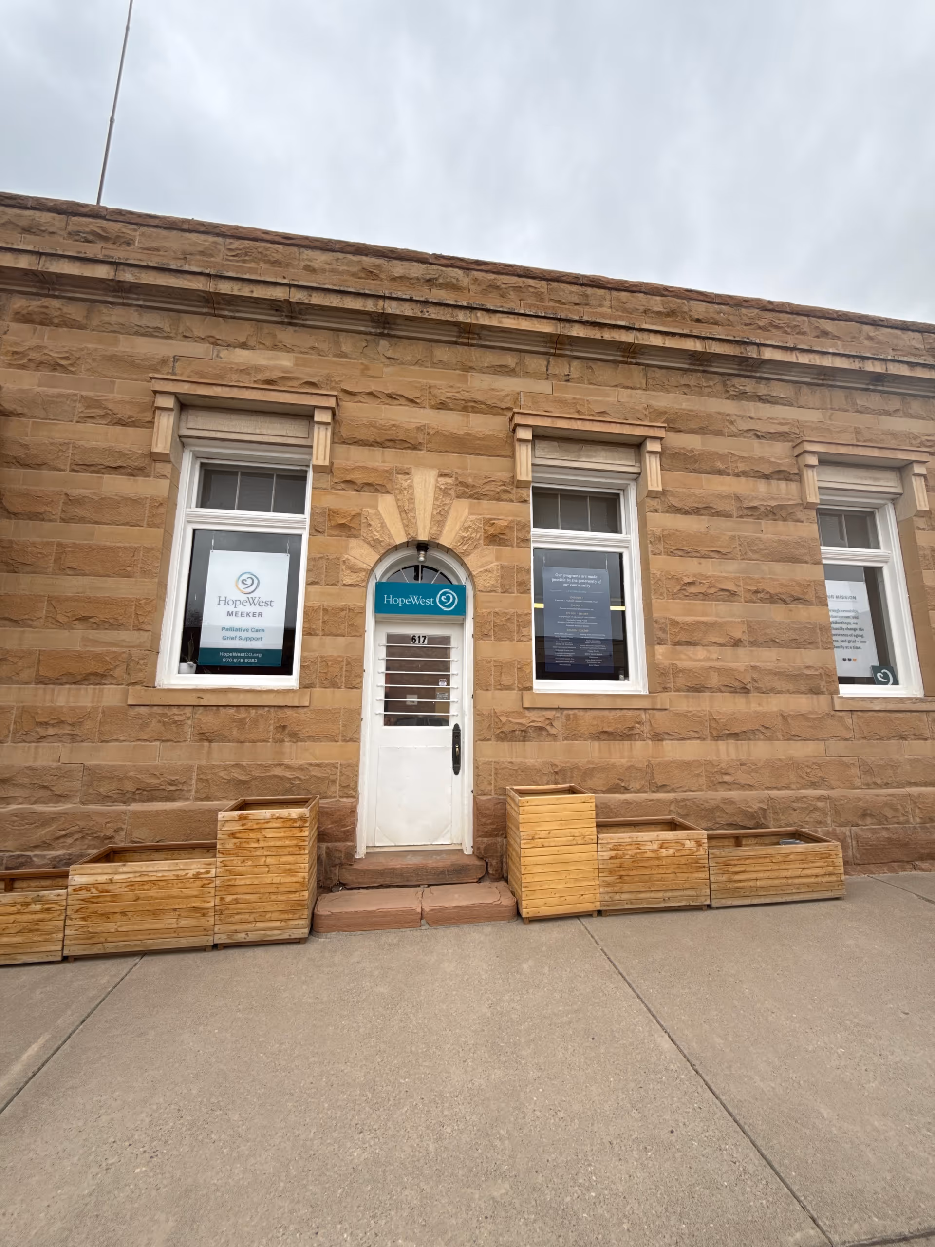 HopeWest Administrative Offices housed in a stone building with a central arched doorway.