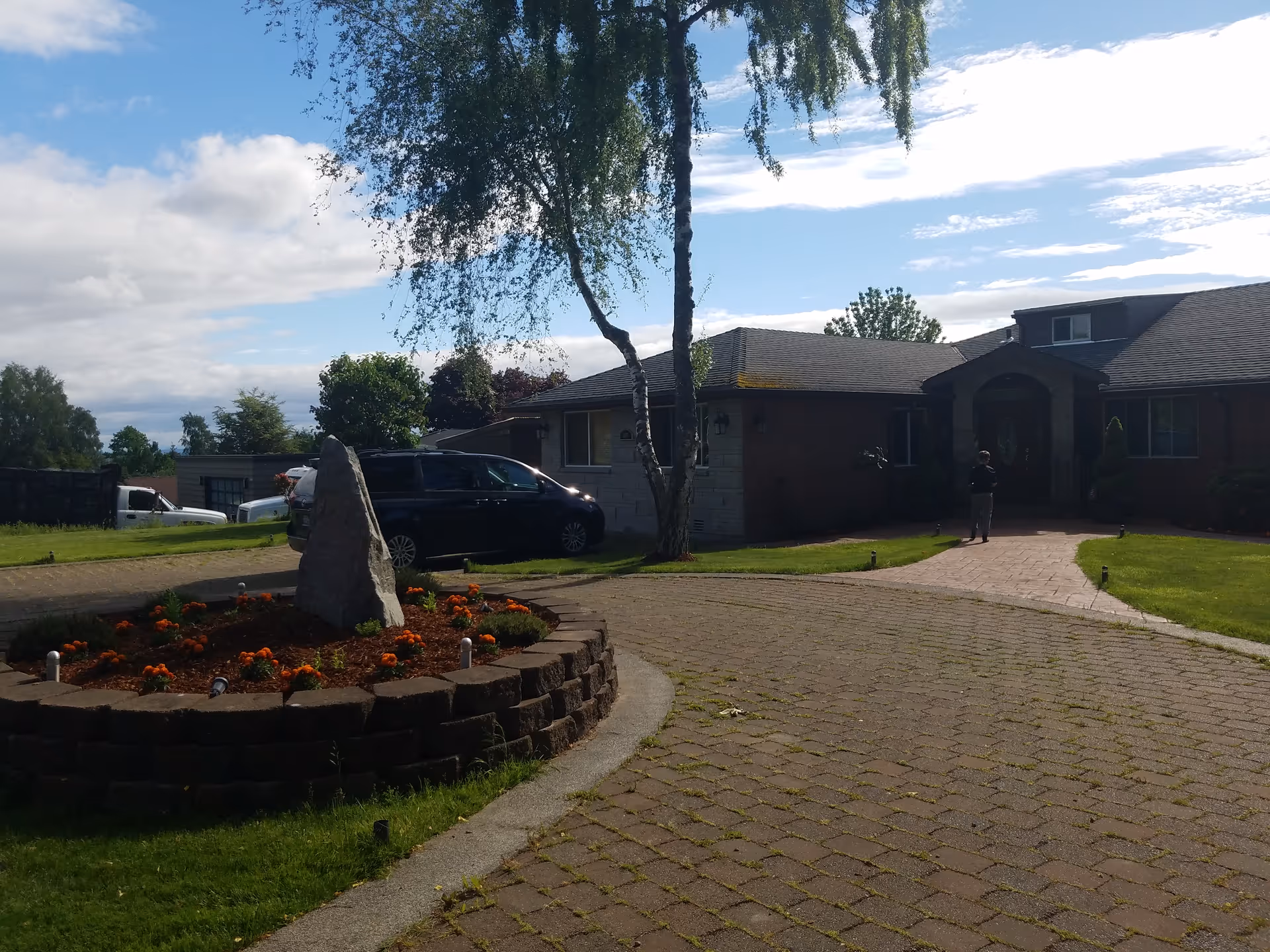 Exterior view of Overlake View AFH with brick building, driveway, and landscaped flower bed.