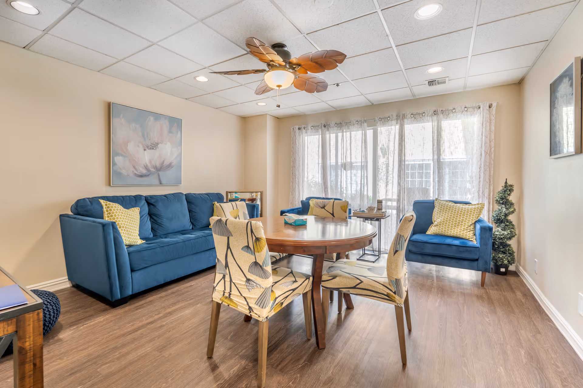 Blue sofas and chairs surround a round table in a cozy living room.
