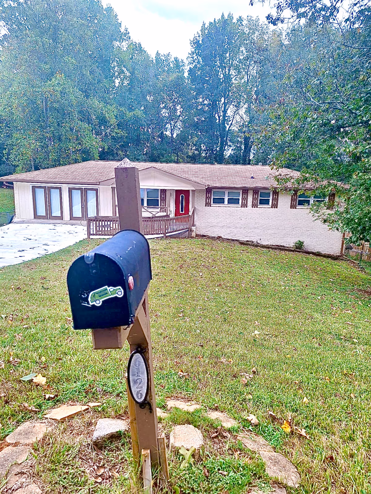 Front view of a single-story house with a mailbox in a grassy yard.