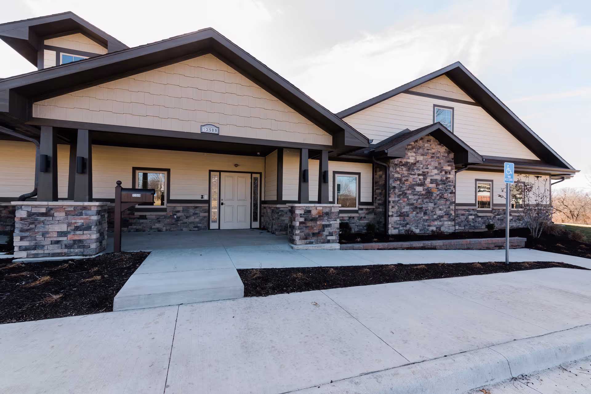 Exterior view of The Cottages at Shawnee, a senior living facility with stone accents.