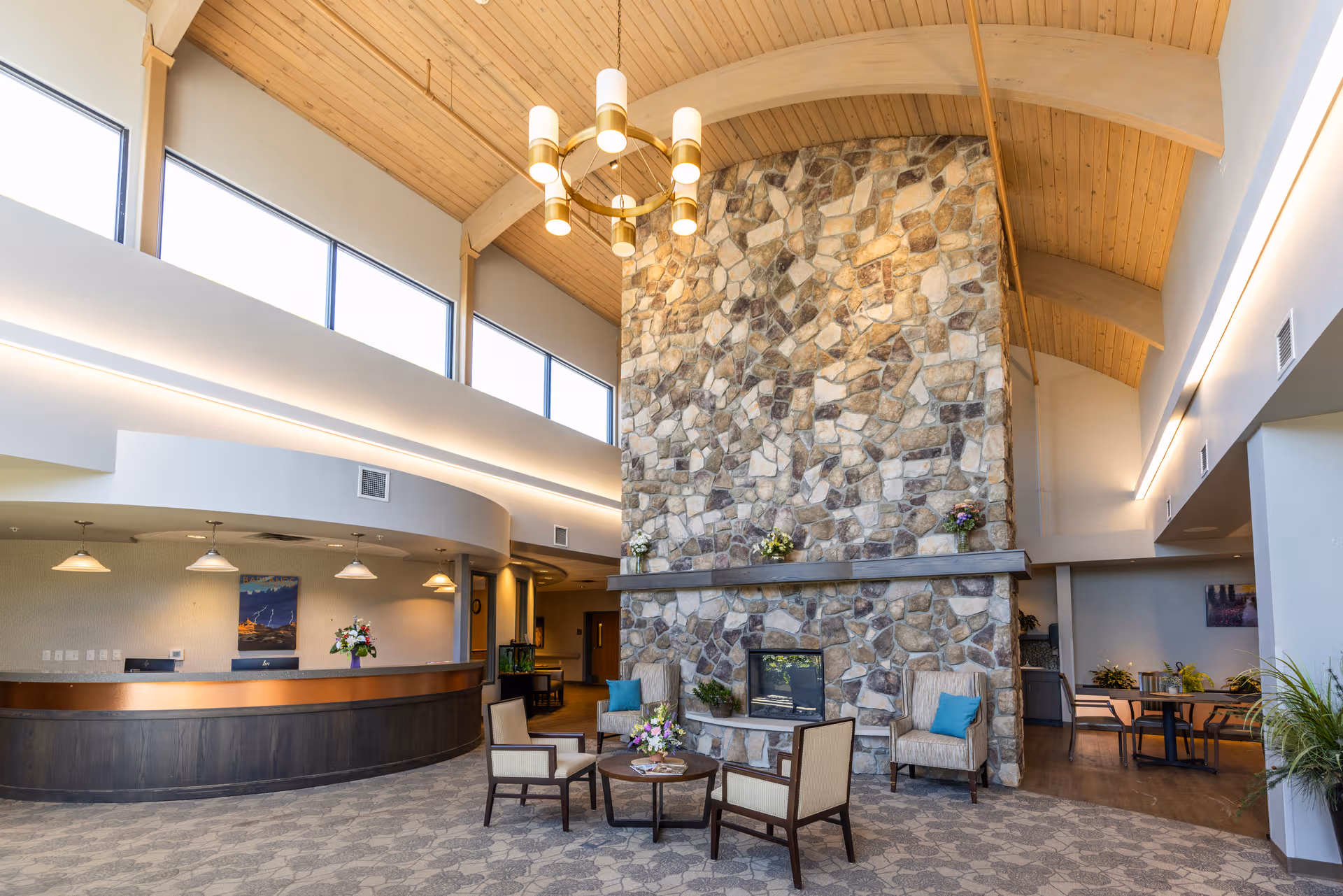 Bright, upscale senior living facility lobby with stone fireplace and seating area.
