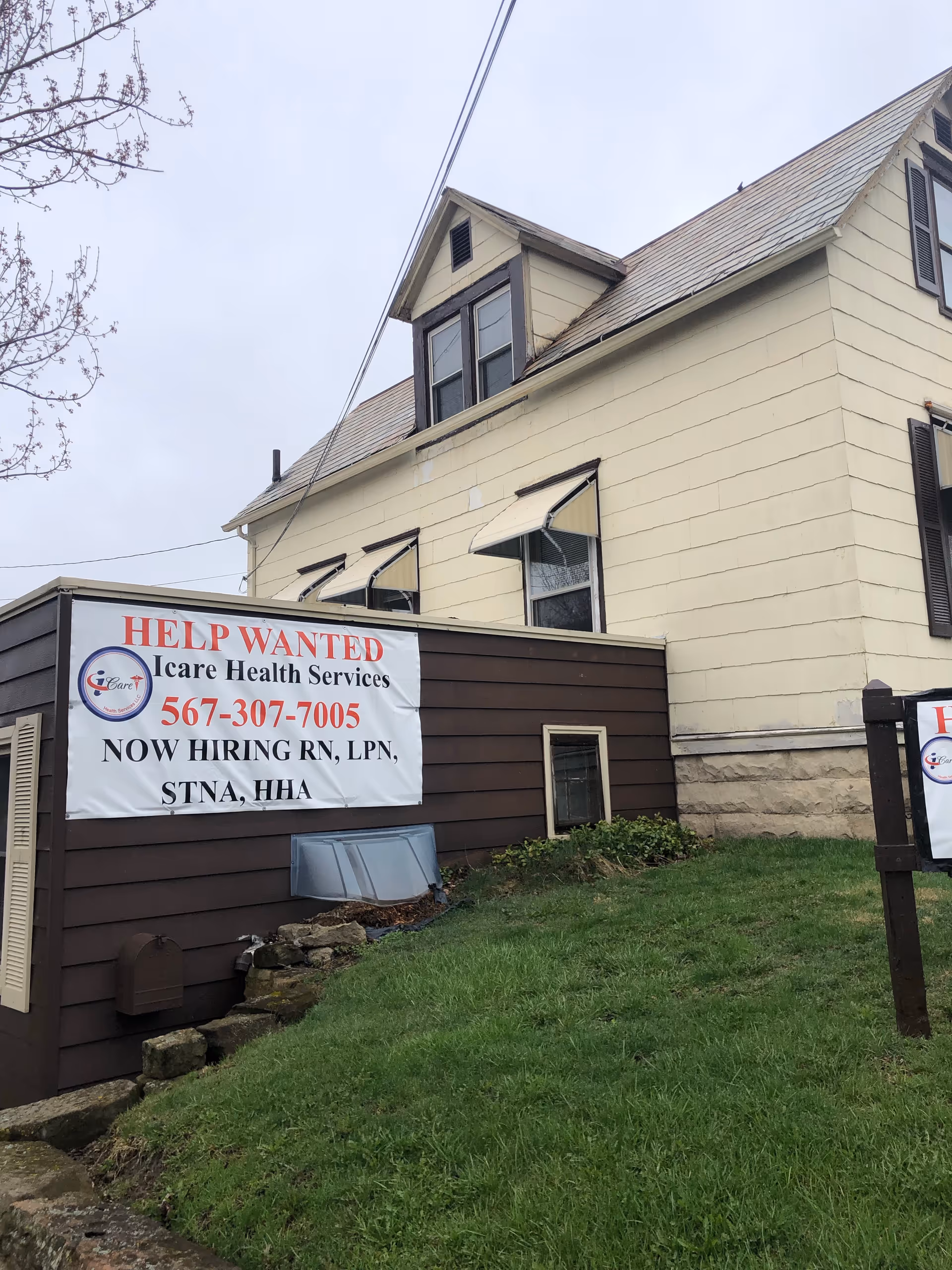 Exterior view of a beige building with an iCare Health Services help-wanted banner