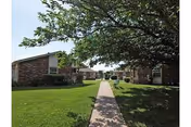 Prairie Villa exterior: brick buildings connected by a central walkway on a sunny campus.