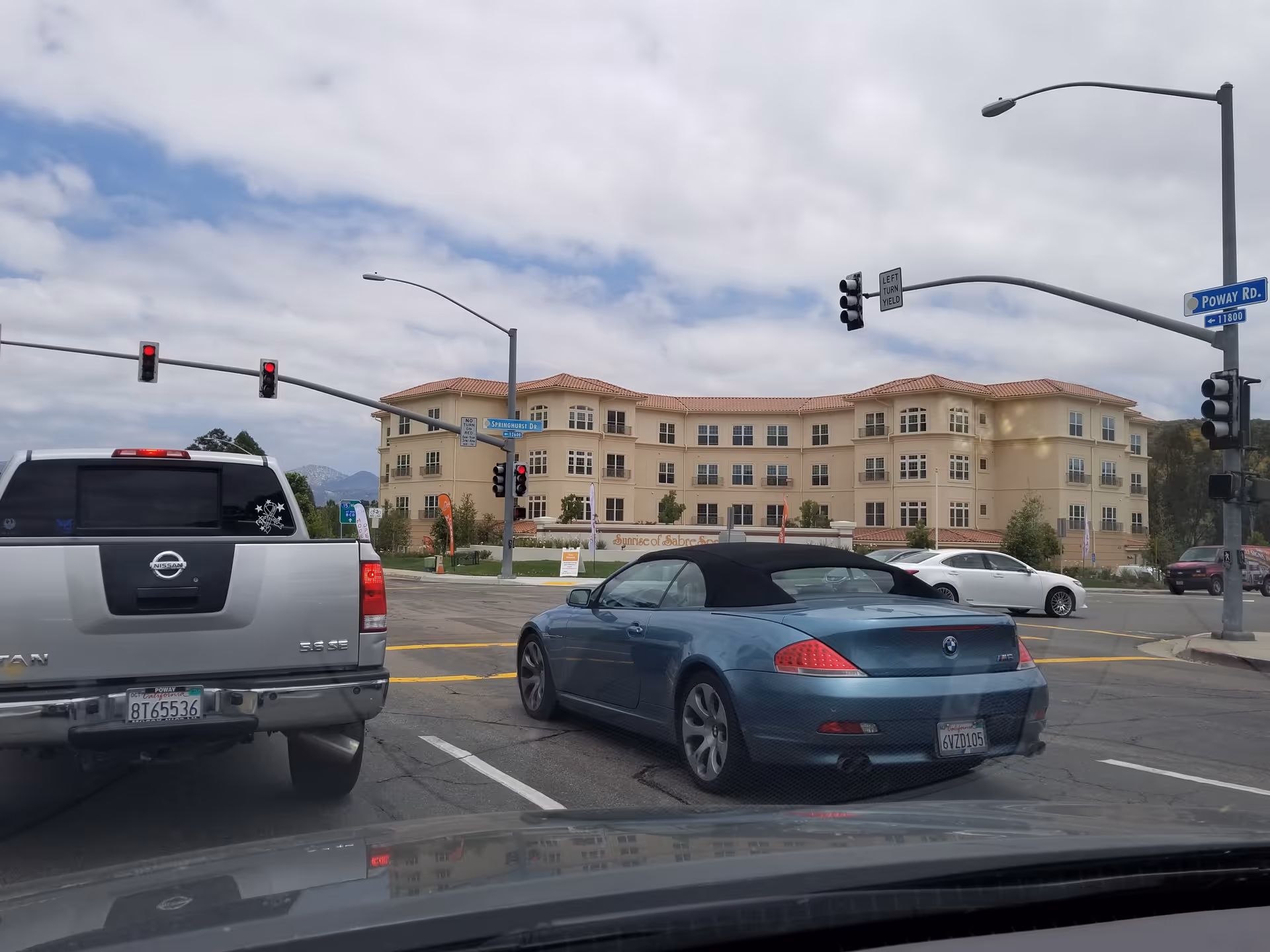 Exterior view of Ivy Park at Sabre Springs, with cars at a street intersection.