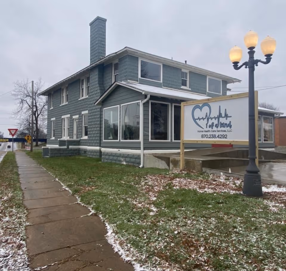 Exterior view of a blue two-story senior care building with a frontage sign.