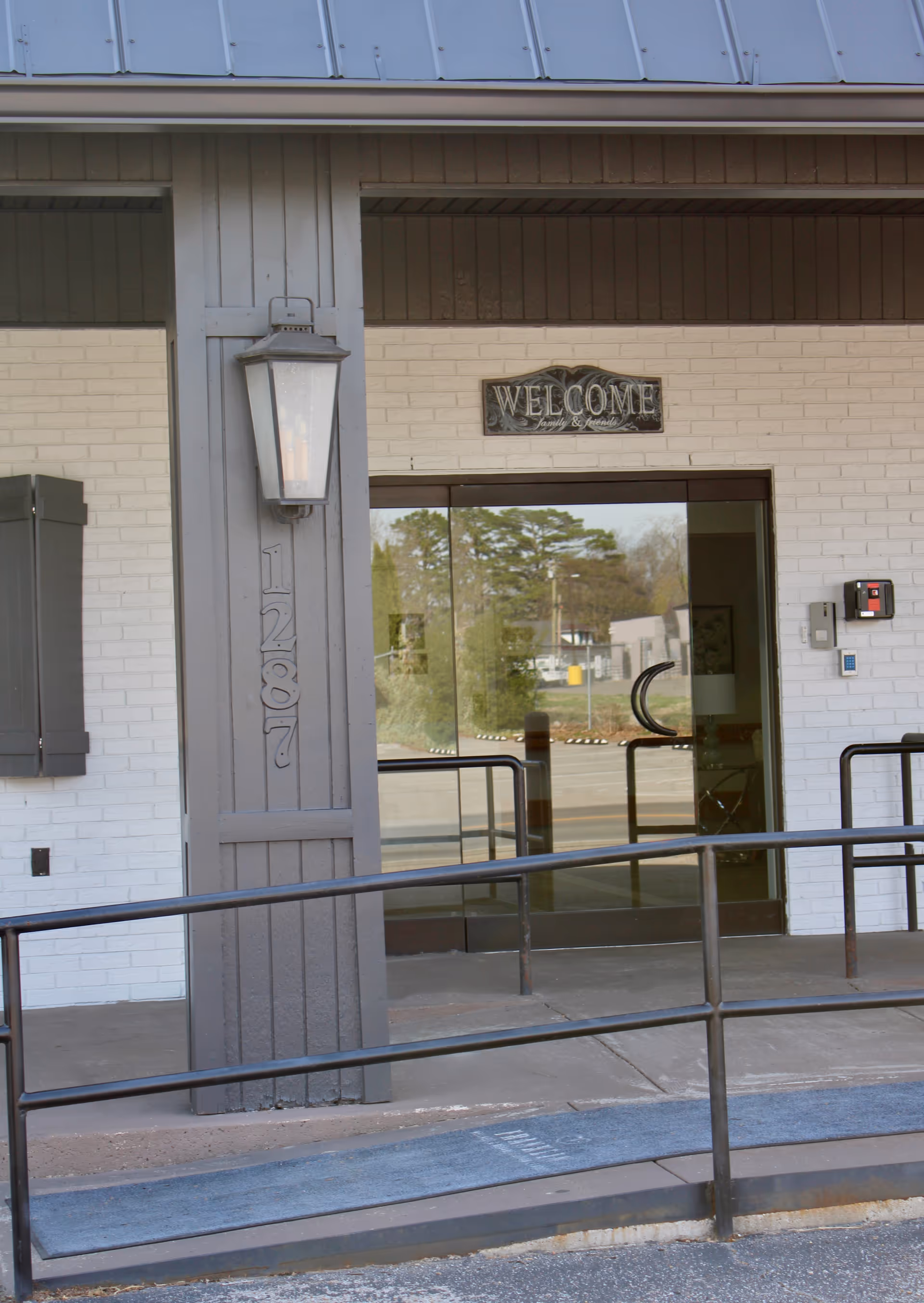 Front entrance of Franklin Wellness and Rehabilitation Center with glass doors and a welcoming sign.