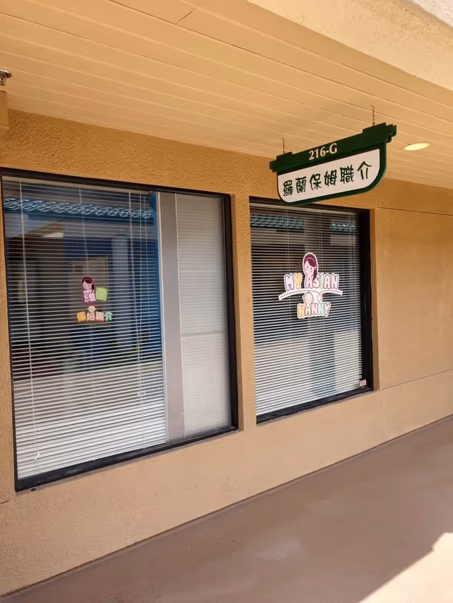 Beige-walled storefront exterior with large windows and a hanging sign reading My Asian Nanny Inc.
