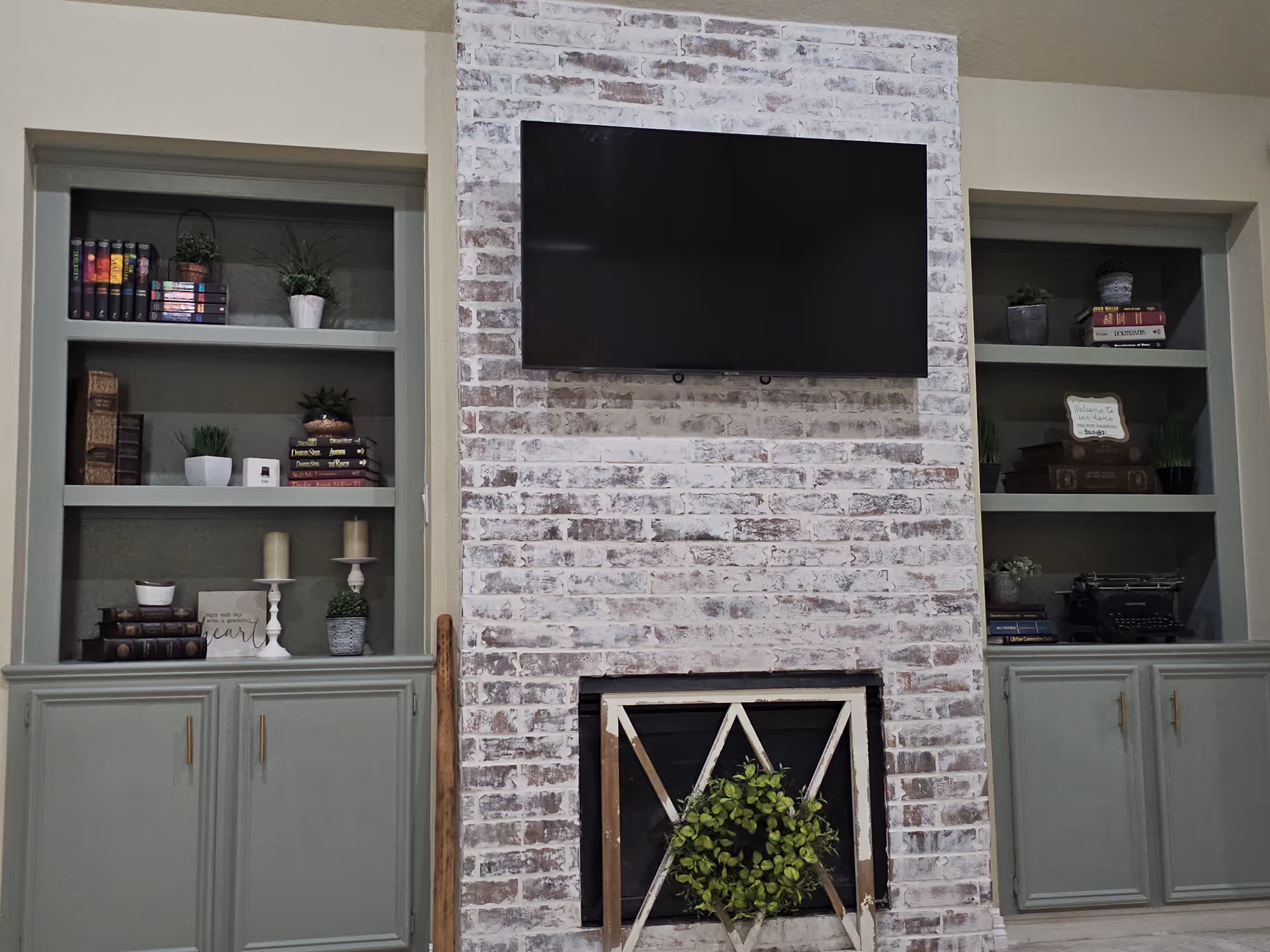 Brick fireplace with mounted TV and light gray built-in shelving.