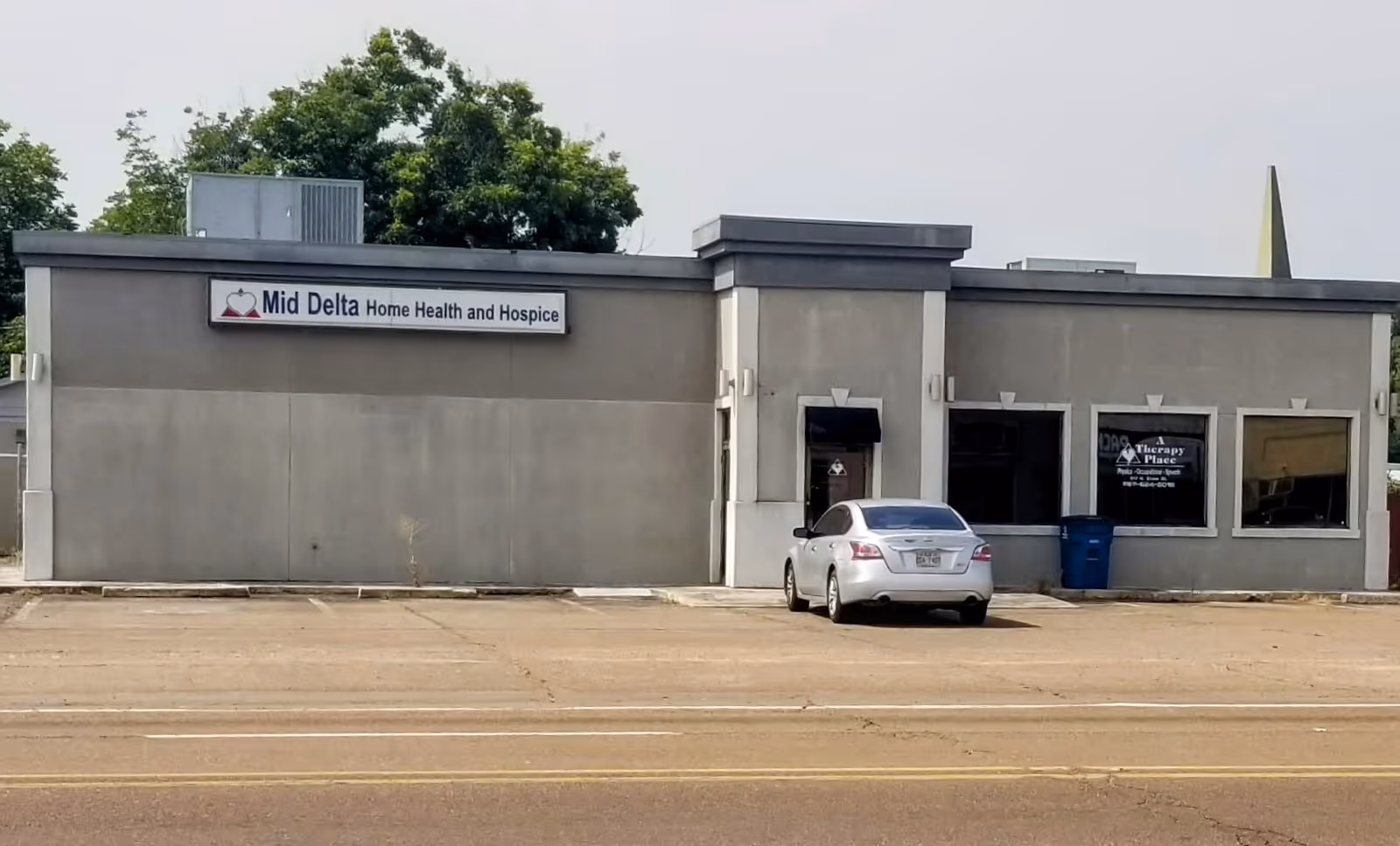 Mid-Delta building front exterior with a silver car parked in the lot.