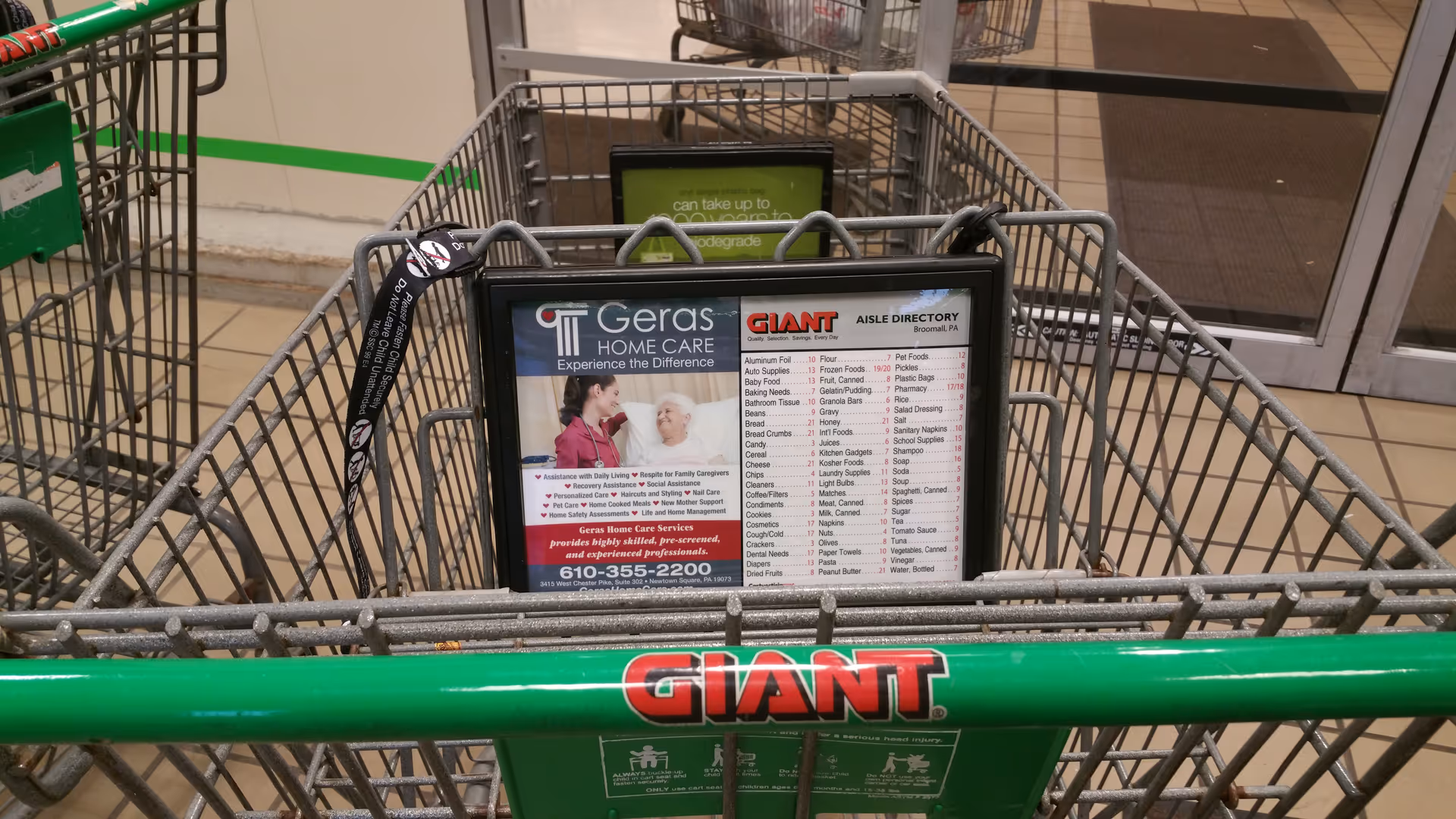 Shopping carts in a grocery store display a Geras Home Care advertisement.