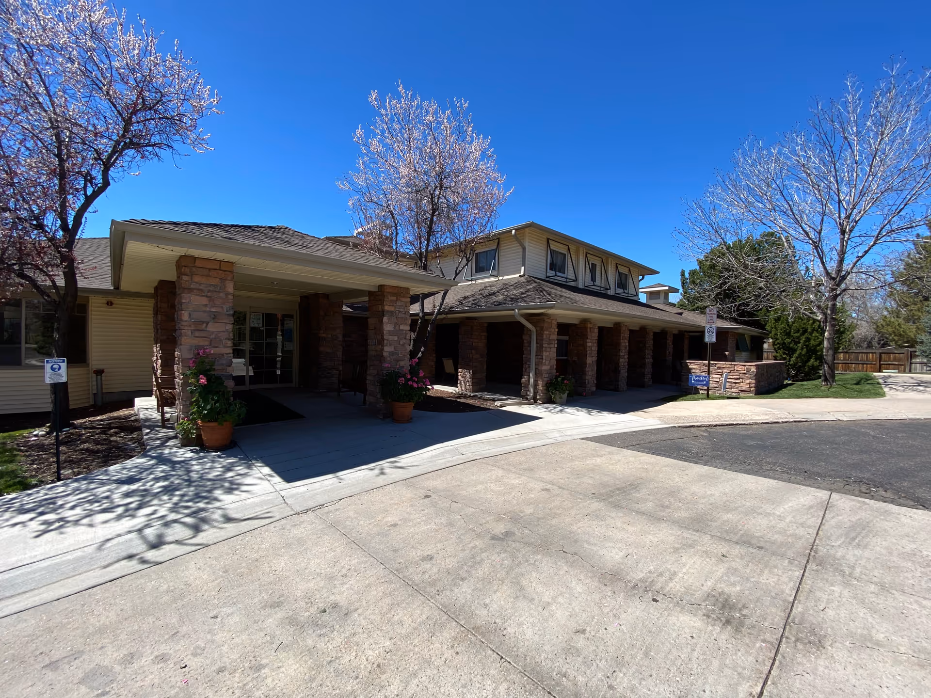 Exterior view of The Oberon House entrance with pillars, trees, and a sidewalk.