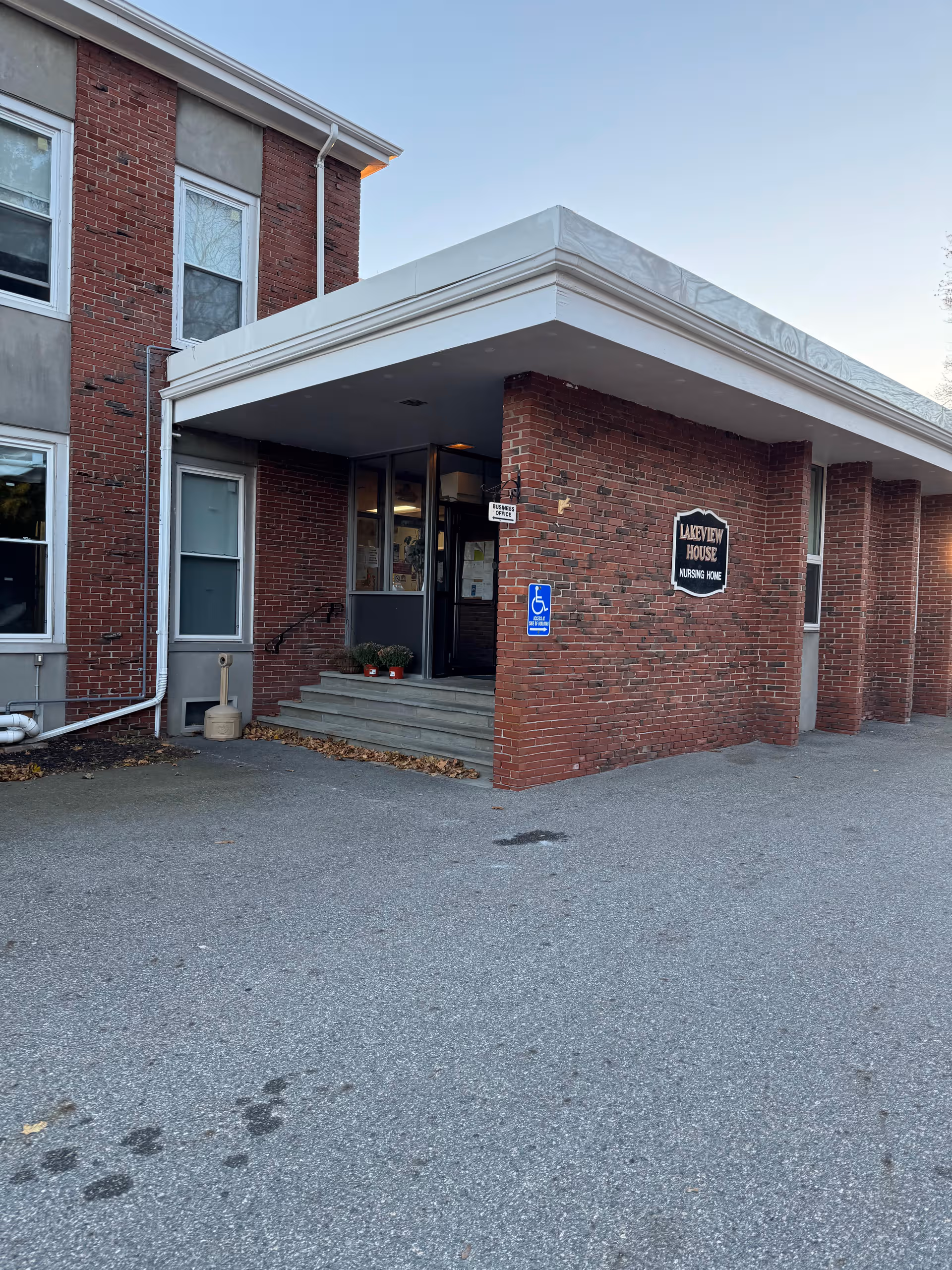Brick building entrance with stairs, Lakeview House Nursing Home sign, and handicapped parking.