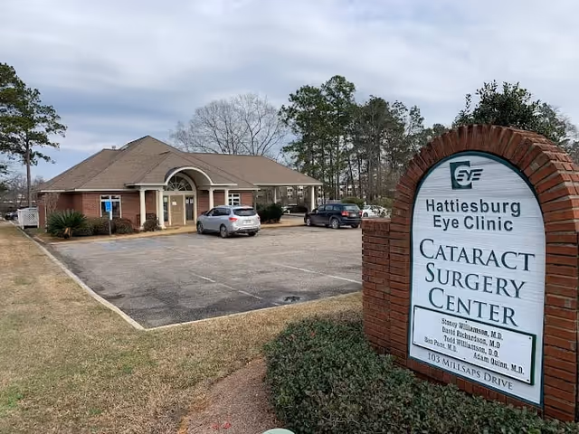 Exterior view of Hattiesburg Eye Clinic building with parking lot and sign.