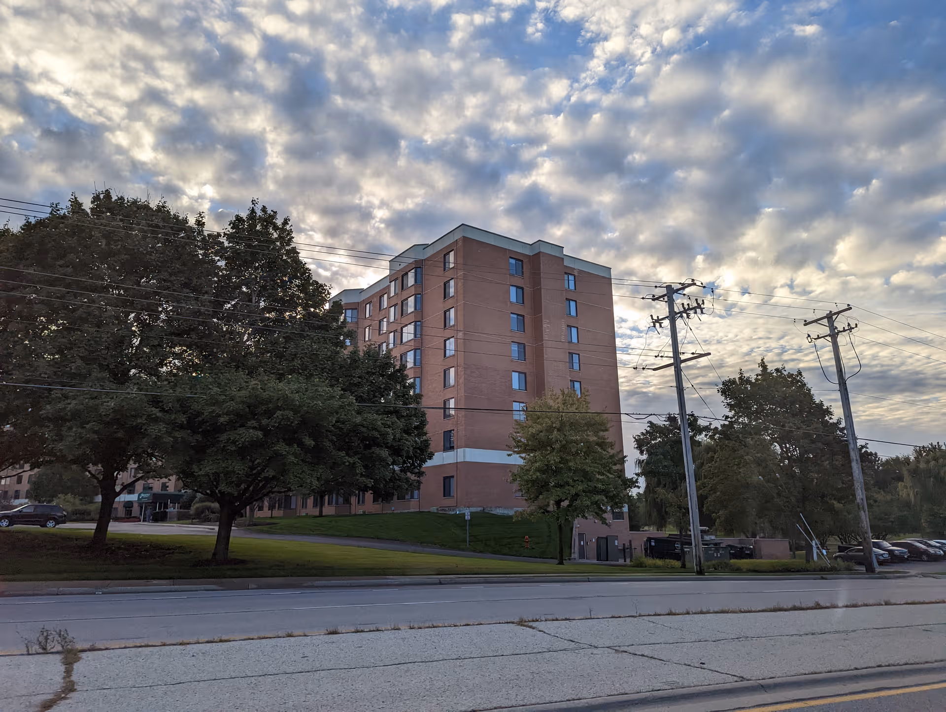 Brookdale Hoffman Estates exterior: brick senior living building with trees along a street.