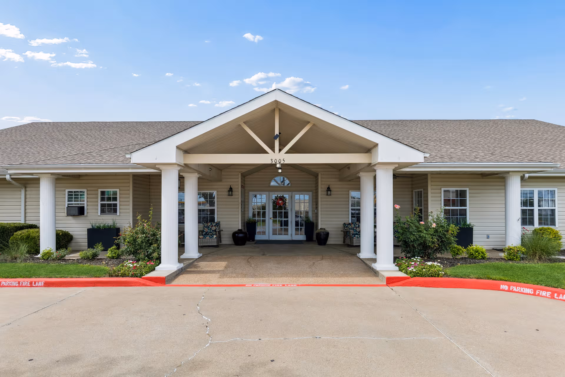Senior living facility Lakewell Court front entrance with columns and landscaped walkway.