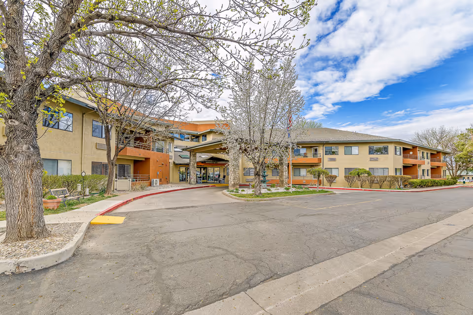 Exterior view of Solstice Senior Living at Mesa View with entrance and trees.