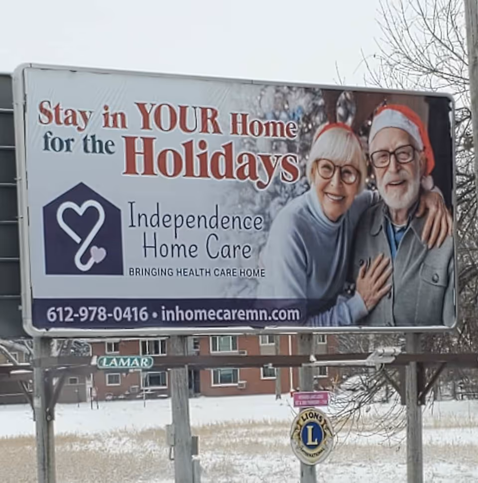 Outdoor billboard for Independence Home Care showing an elderly couple wearing Santa hats.