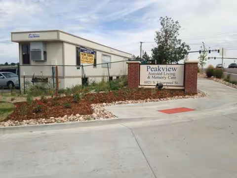 Front exterior of Peakview Assisted Living and Memory Care with a sign and landscaped entrance.
