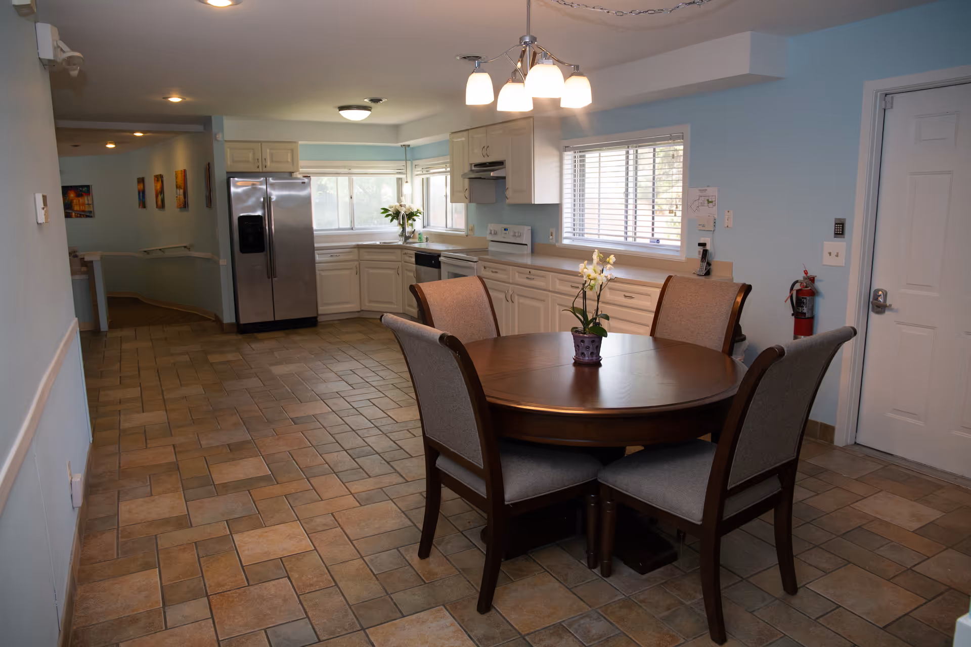 Circular dining table with six upholstered chairs in a bright kitchen-dining area.