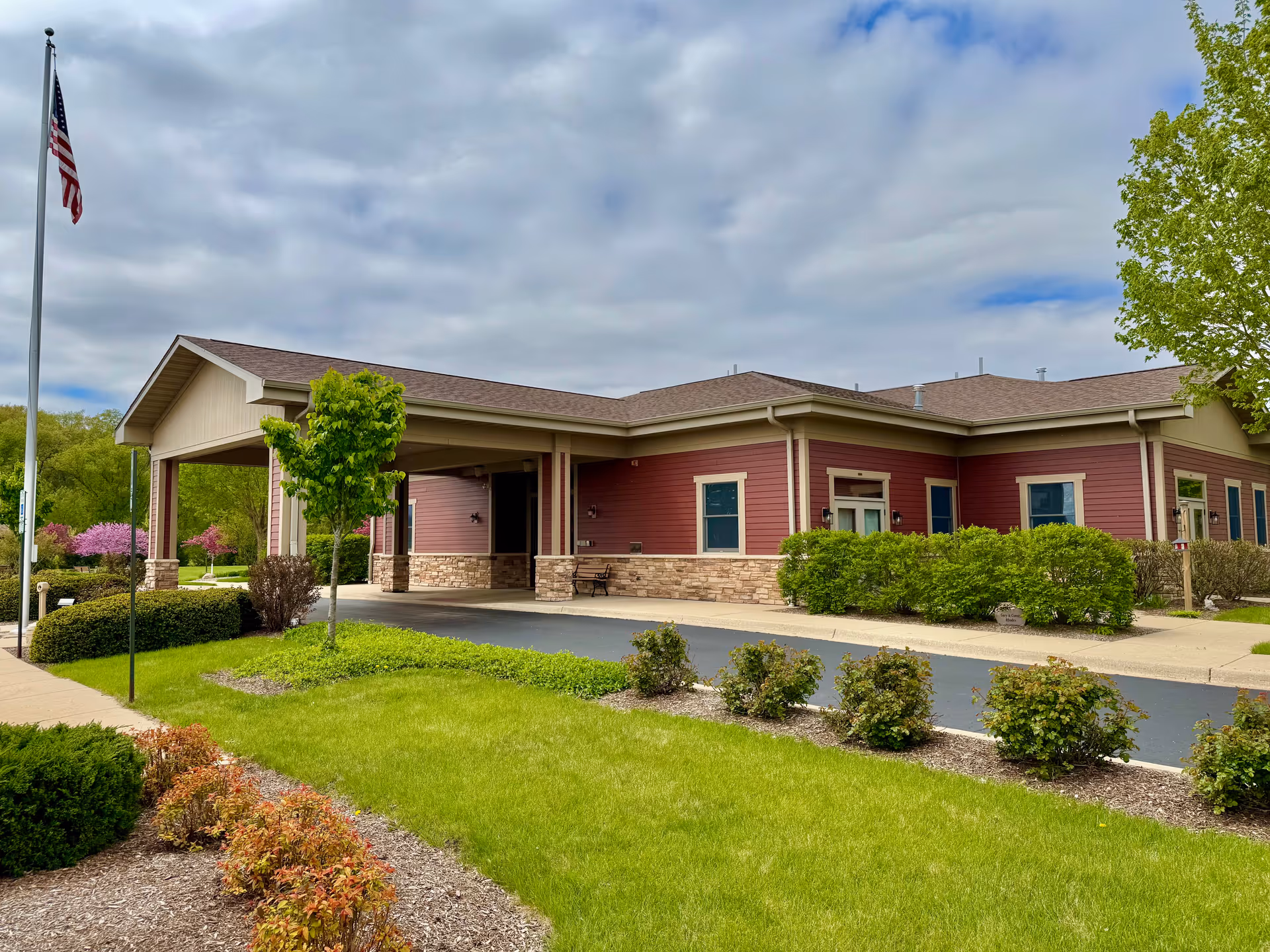 Exterior view of Serenity Hospice and Home building with a covered entrance and manicured lawn.
