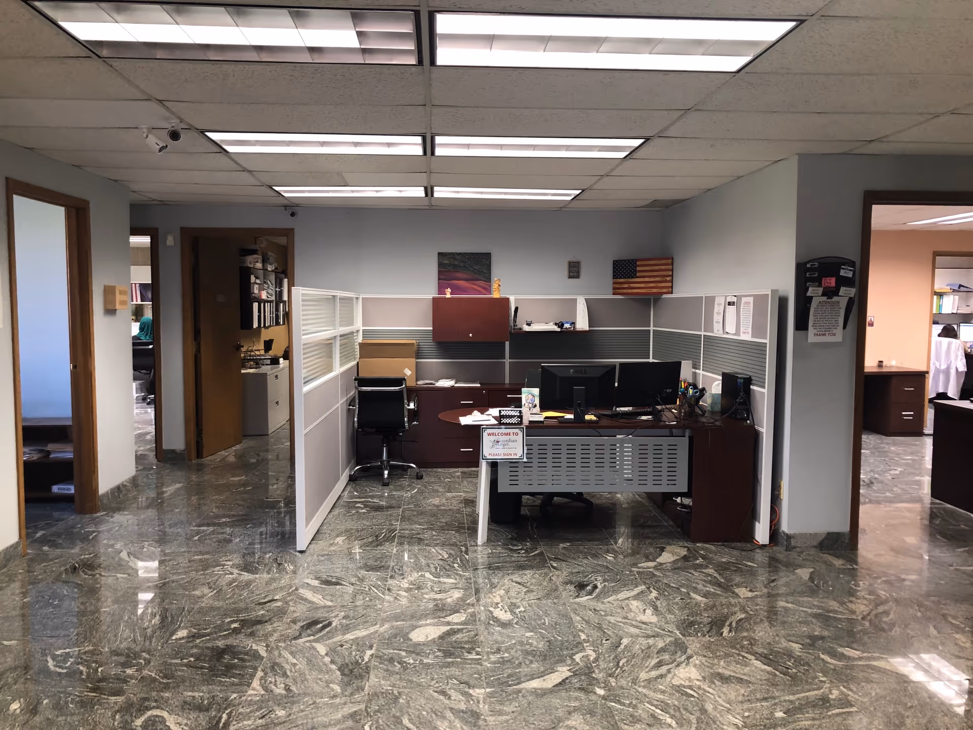 Reception area with cubicle desks and computers inside a senior care facility.