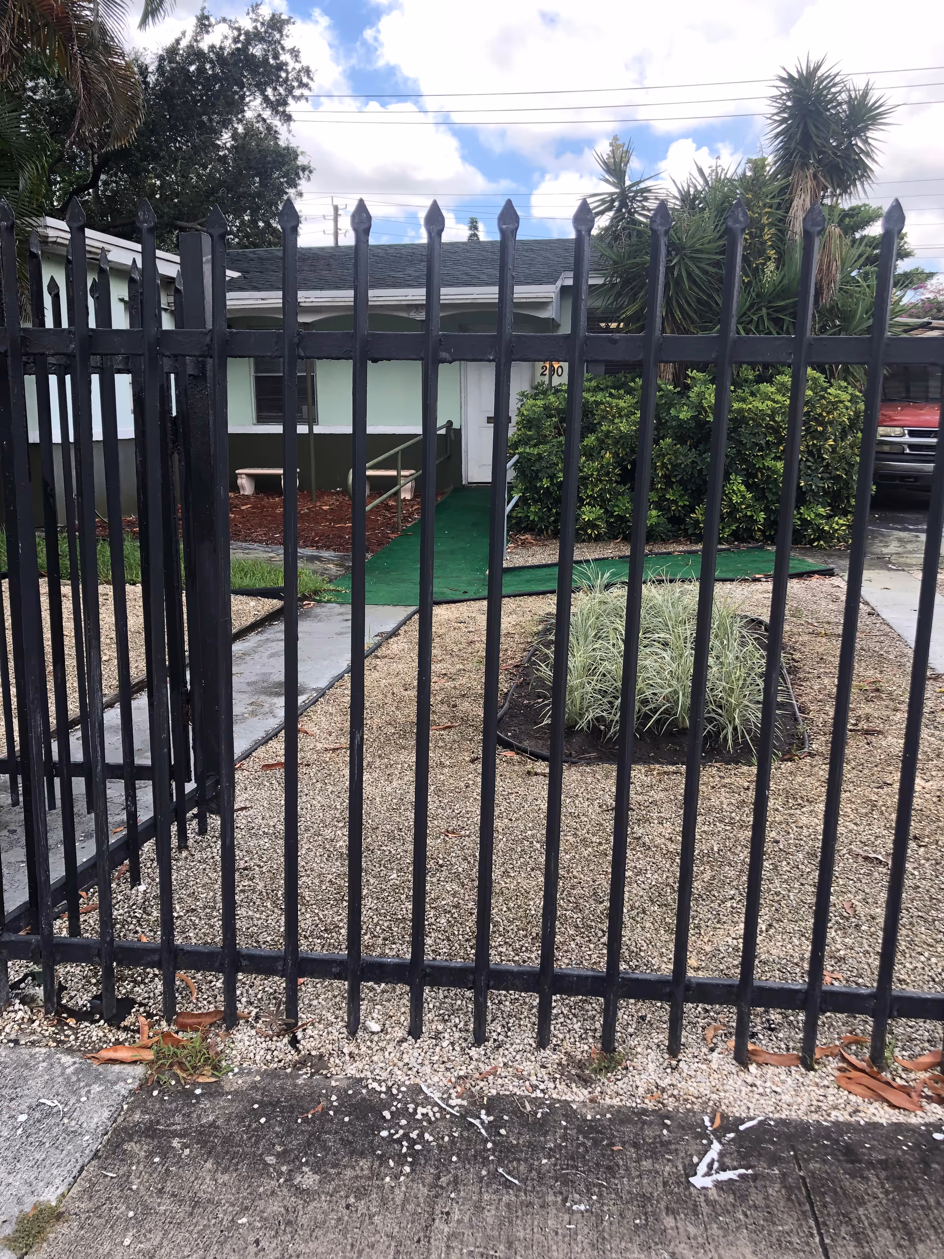 Exterior view of a gated walkway to a senior facility entrance.