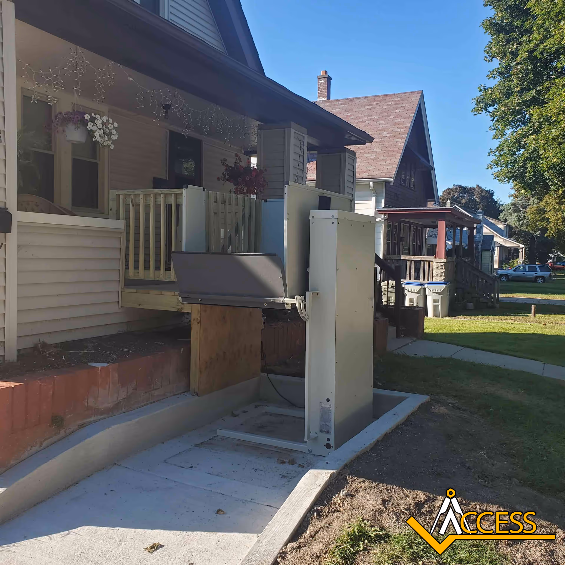 Residential porch with an outdoor vertical platform lift beside the entry.