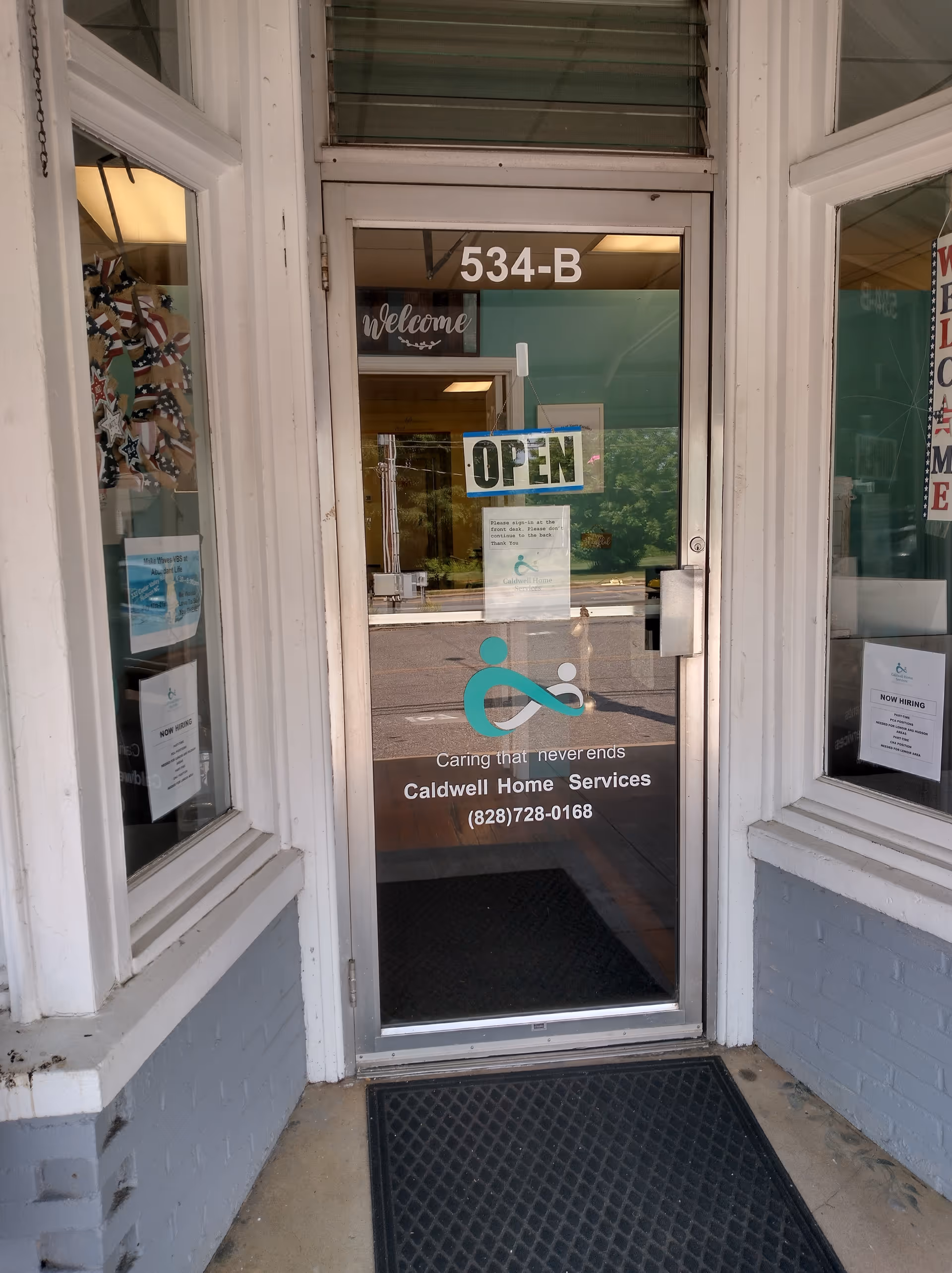 Entrance door to Caldwell Home Services with an open sign and logo