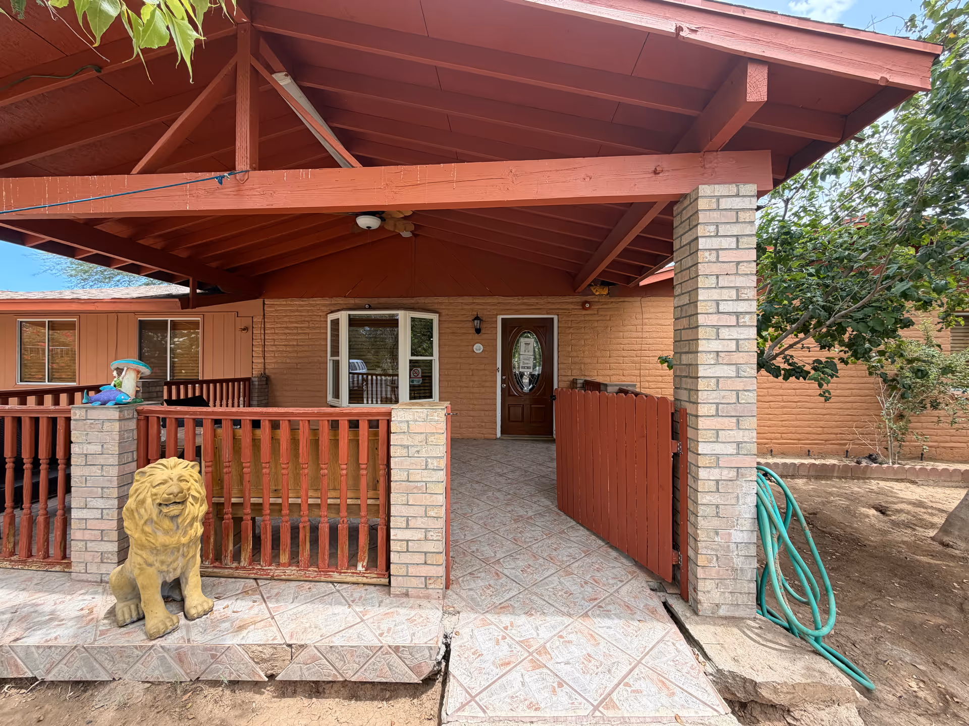 Front entrance of Desert View Adult Care Home with red railing and lion statue.