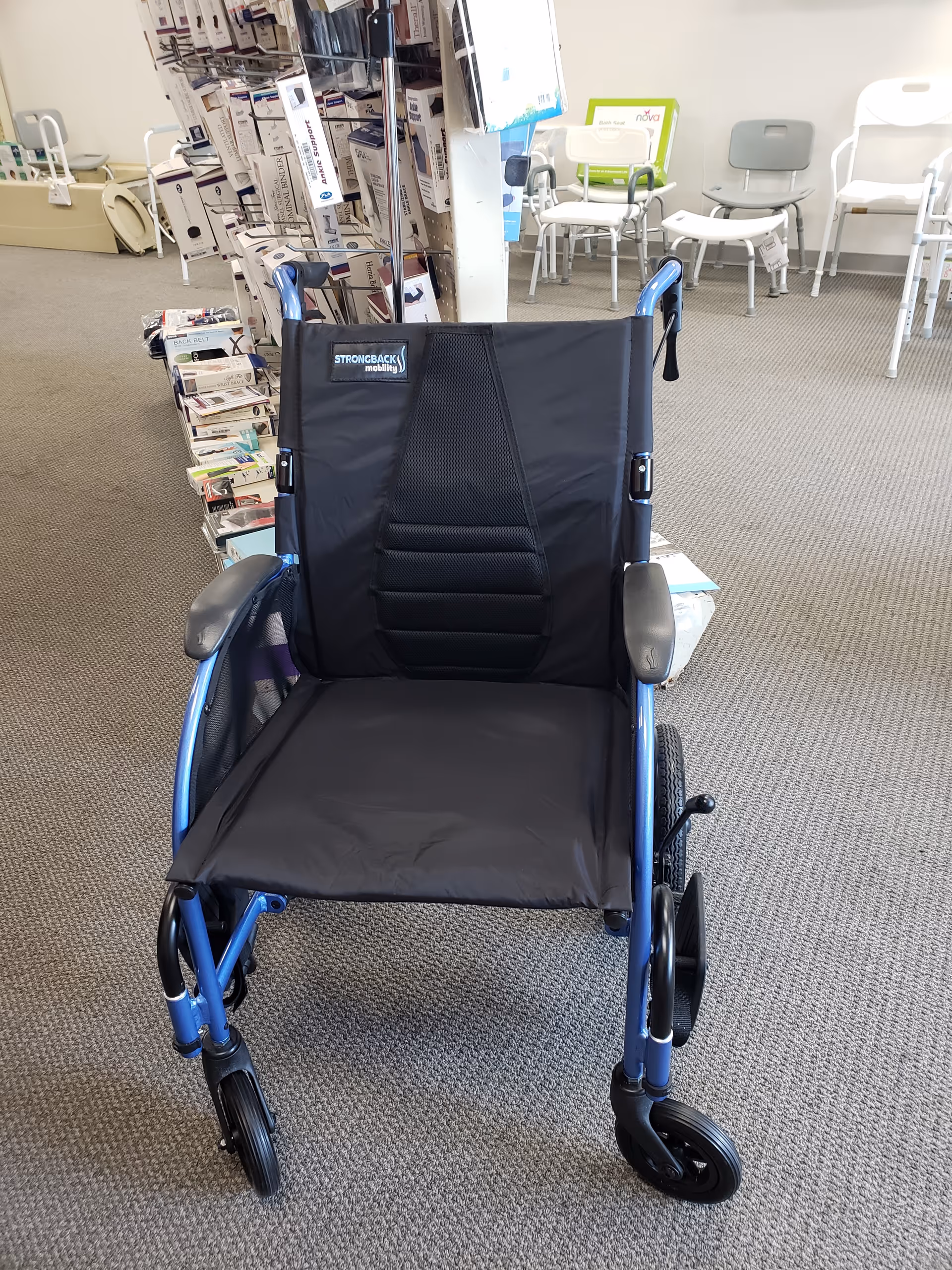 A wheelchair in a clinic lobby with pamphlet racks and waiting chairs.